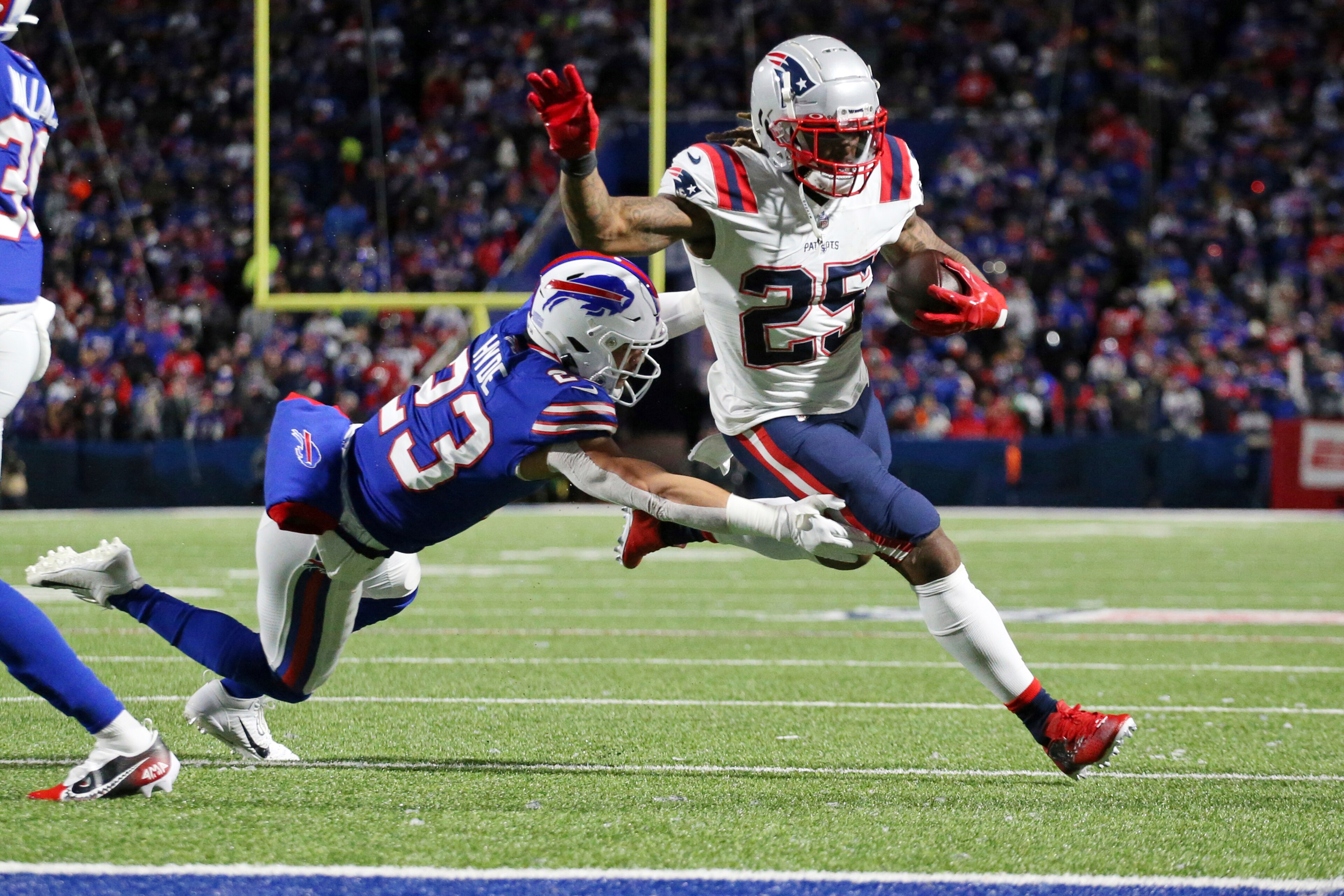 New England Patriots running back Brandon Bolden (25) gets past Buffalo Bills safety Micah Hyde (23) for a two-point conversion after a touchdown run by Patriots running back Damien Harris during the first half of an NFL football game in Orchard Park, N.Y., Monday, Dec. 6, 2021. (AP Photo/Joshua Bessex )