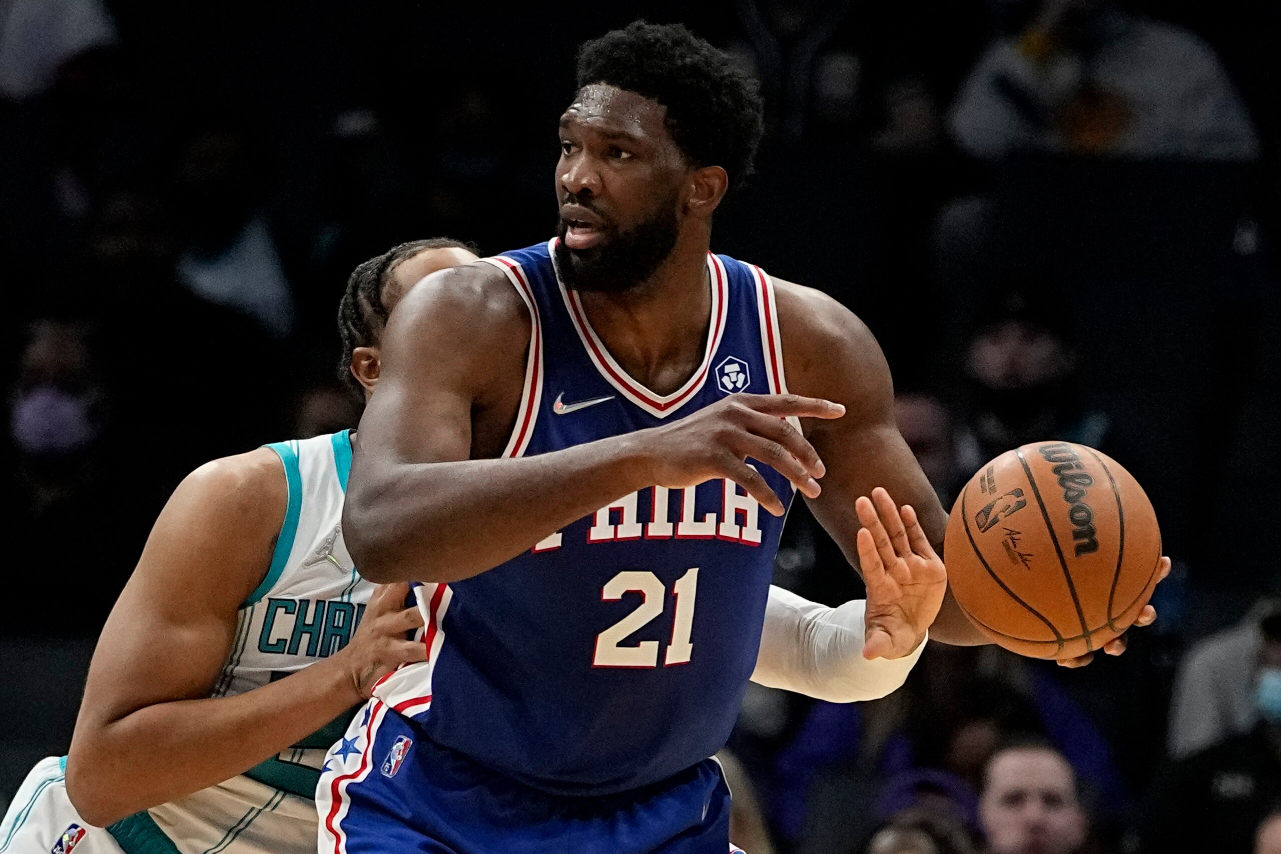 Charlotte Hornets forward P.J. Washington knocks the ball away from Philadelphia 76ers center Joel Embiid during the first half of an NBA basketball game on Monday, Dec. 6, 2021, in Charlotte, N.C. (AP Photo/Chris Carlson)