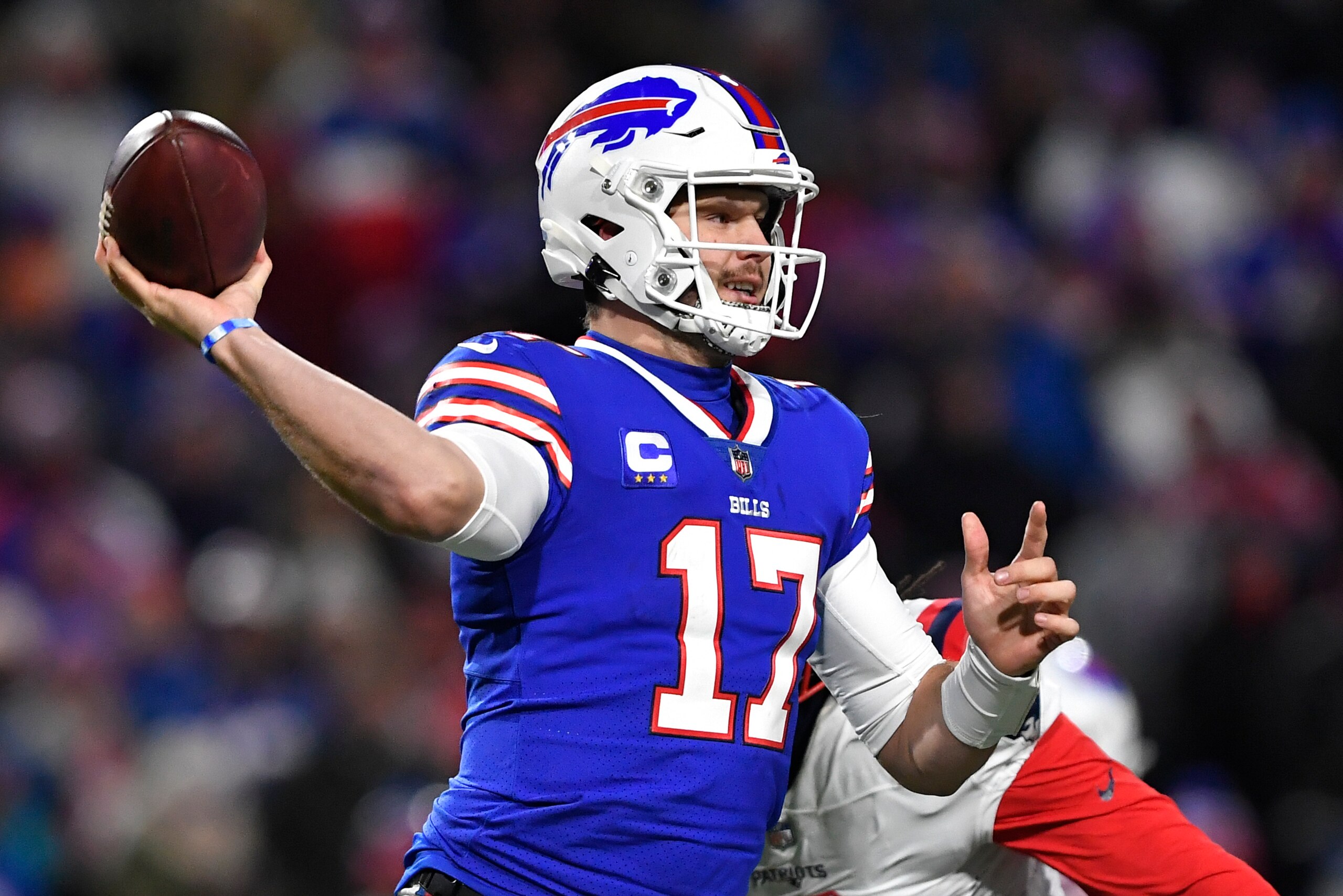 Buffalo Bills quarterback Josh Allen (17) passes under pressure by New England Patriots outside linebacker Matt Judon (9) during the first half of an NFL football game in Orchard Park, N.Y., Monday, Dec. 6, 2021. (AP Photo/Adrian Kraus)