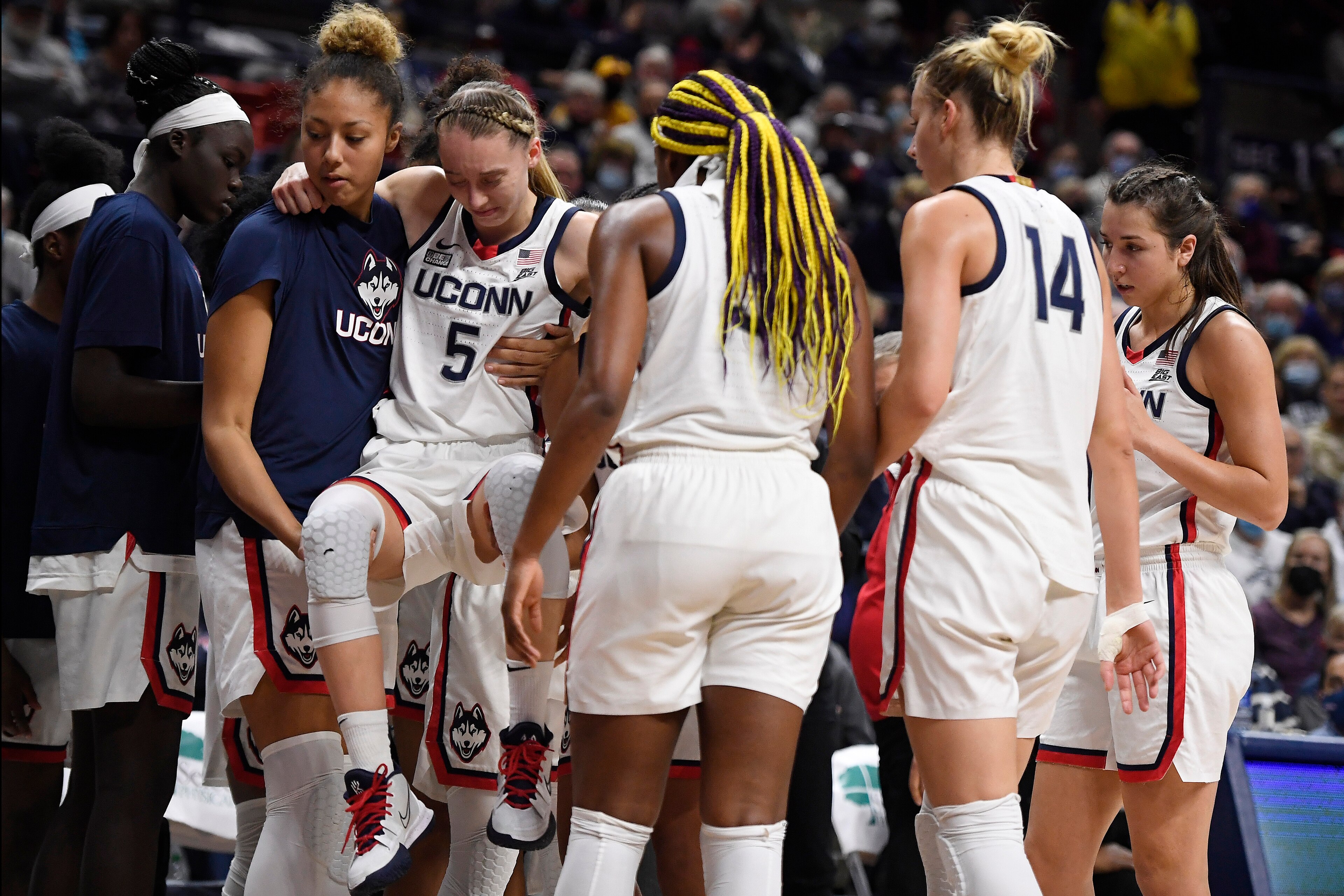 Connecticut's Paige Bueckers (5) is helped off the court by Amari DeBerrym, left, after injuring herself in the second half of an NCAA college basketball game against Notre Dame, Sunday, Dec. 5, 2021, in Storrs, Conn. (AP Photo/Jessica Hill) Connecticut's Paige Bueckers (5) is helped off the court by Amari DeBerrym, left, after injuring herself in the second half of an NCAA college basketball game against Notre Dame, Sunday, Dec. 5, 2021, in Storrs, Conn. (AP Photo/Jessica Hill)