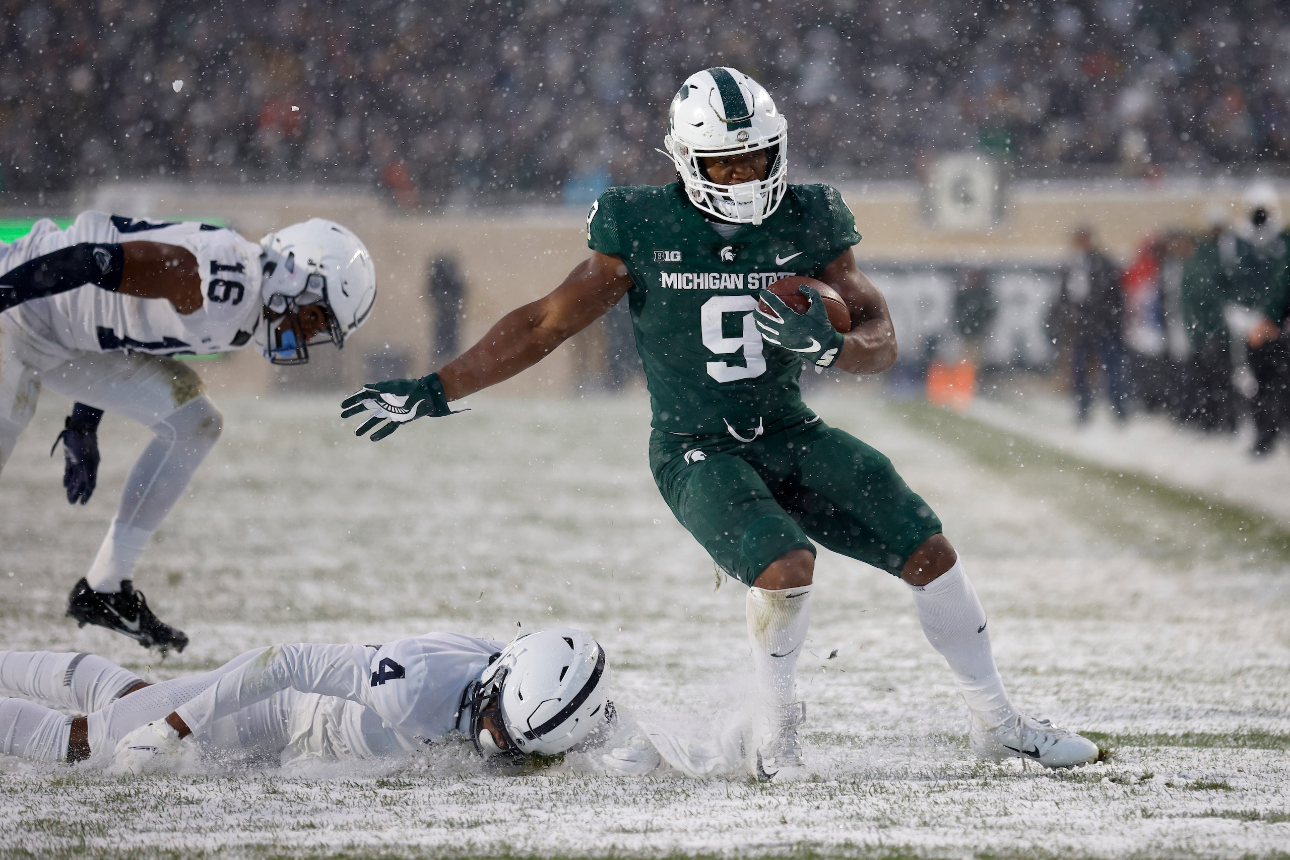 Michigan State's Kenneth Walker III, right, rushes against Penn State's Kalen King (4) and Ji'Ayir Brown (16) during an NCAA college football game, Saturday, Nov. 27, 2021, in East Lansing, Mich. (AP Photo/Al Goldis) Michigan State's Kenneth Walker III, right, rushes against Penn State's Kalen King (4) and Ji'Ayir Brown (16) during an NCAA college football game, Saturday, Nov. 27, 2021, in East Lansing, Mich. (AP Photo/Al Goldis)
