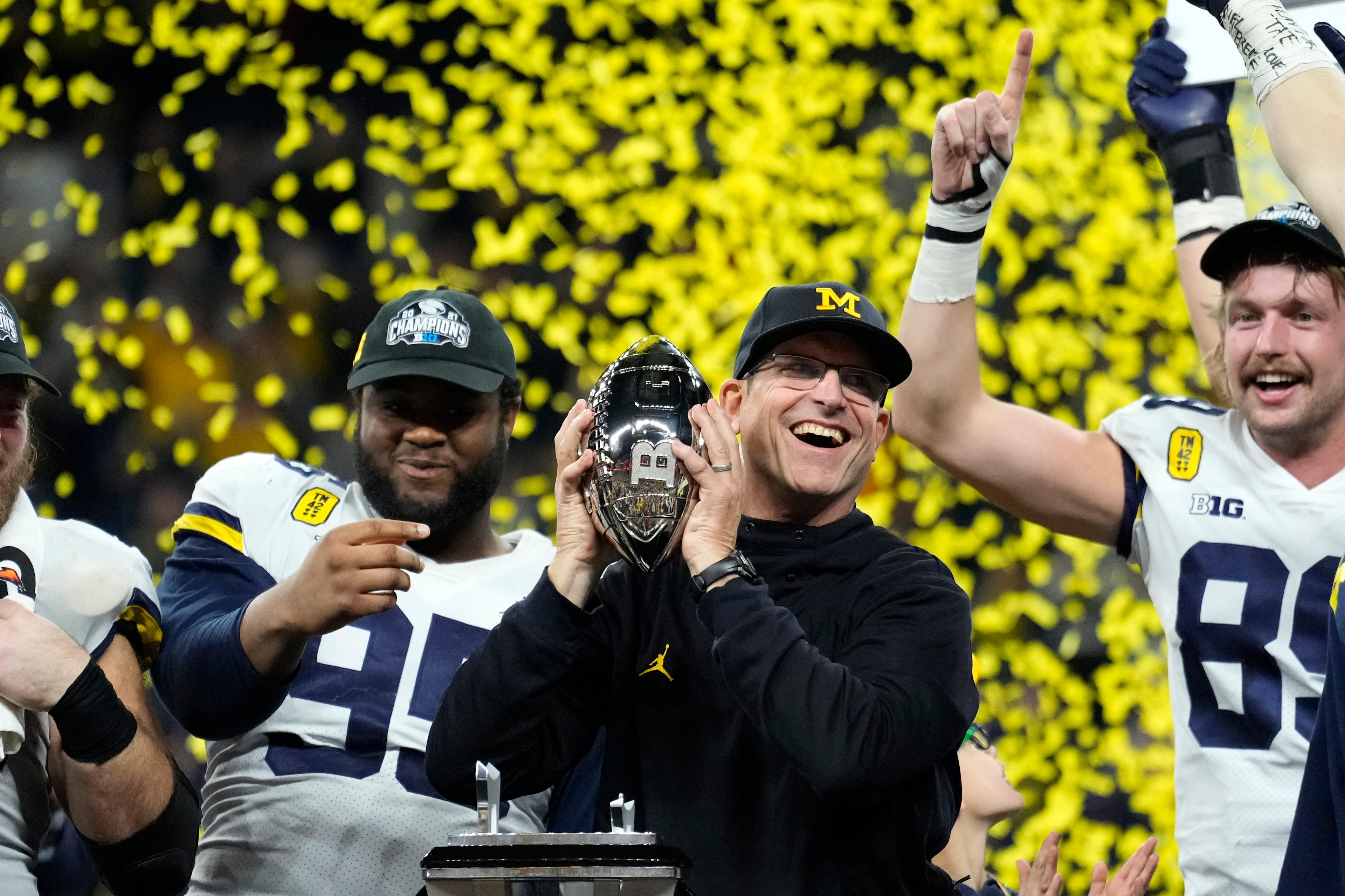 Michigan head coach Jim Harbaugh celebrates with his team after the Big Ten championship NCAA college football game against Iowa, Saturday, Dec. 4, 2021, in Indianapolis. Michigan won 42-3. (AP Photo/AJ Mast) Michigan head coach Jim Harbaugh celebrates with his team after the Big Ten championship NCAA college football game against Iowa, Saturday, Dec. 4, 2021, in Indianapolis. Michigan won 42-3. (AP Photo/AJ Mast)