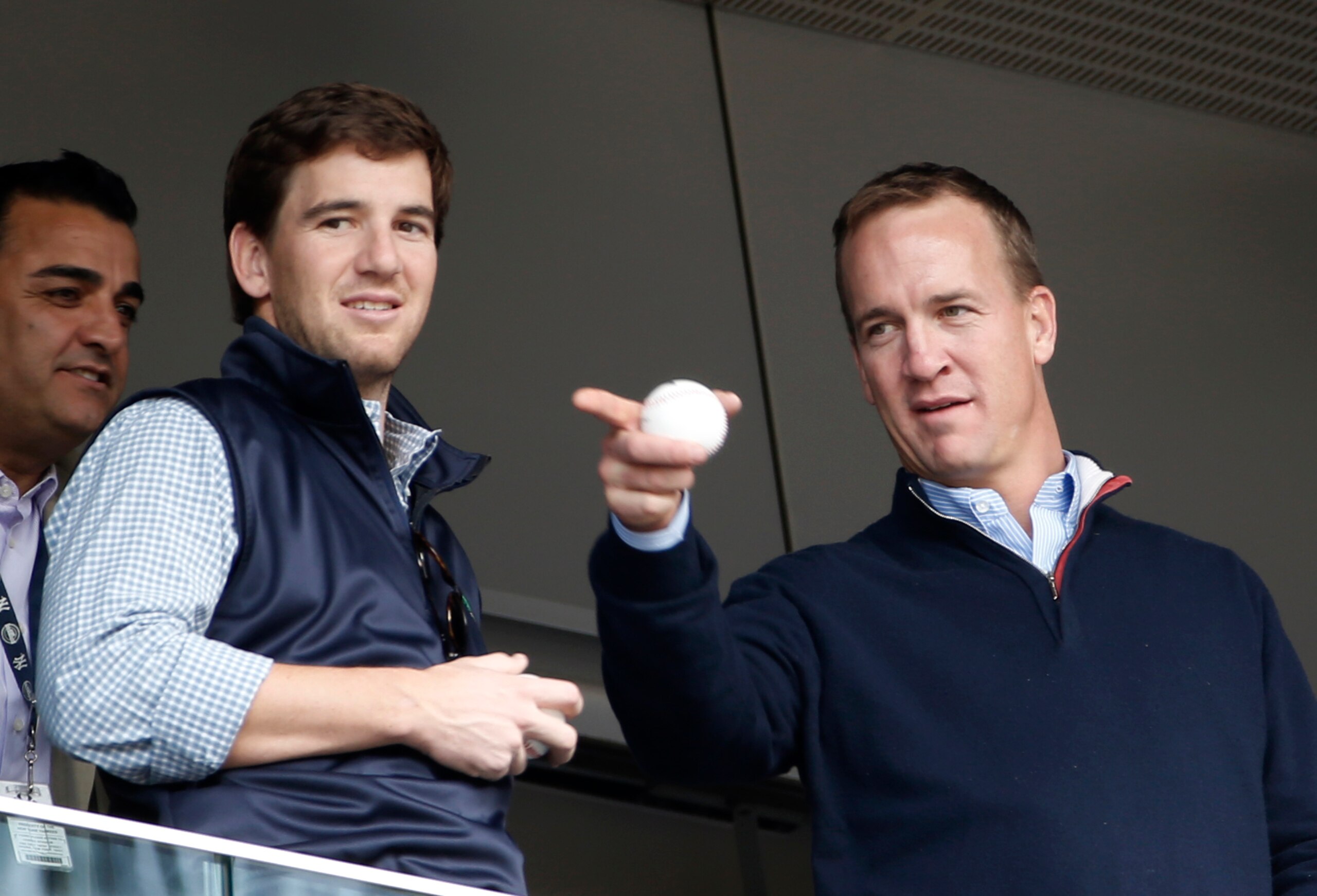 FILE - In this May 4, 2014, file photo, Denver Broncos quarterback Peyton Manning, right, points out something in the stadium to his brother, New York Giants quarterback Eli Manning, from New York Yankees' Derek Jeter's suite during a baseball game between the Yankees and the Tampa Bay Rays at Yankee Stadium in New York. Peyton Manning had a little fun with little brother Eli's sad face at the Super Bowl during an appearance on NBC's "Tonight Show." (AP Photo/Kathy Willens, File) FILE - In this May 4, 2014, file photo, Denver Broncos quarterback Peyton Manning, right, points out something in the stadium to his brother, New York Giants quarterback Eli Manning, from New York Yankees' Derek Jeter's suite during a baseball game between the Yankees and the Tampa Bay Rays at Yankee Stadium in New York. Peyton Manning had a little fun with little brother Eli's sad face at the Super Bowl during an appearance on NBC's "Tonight Show." (AP Photo/Kathy Willens, File)