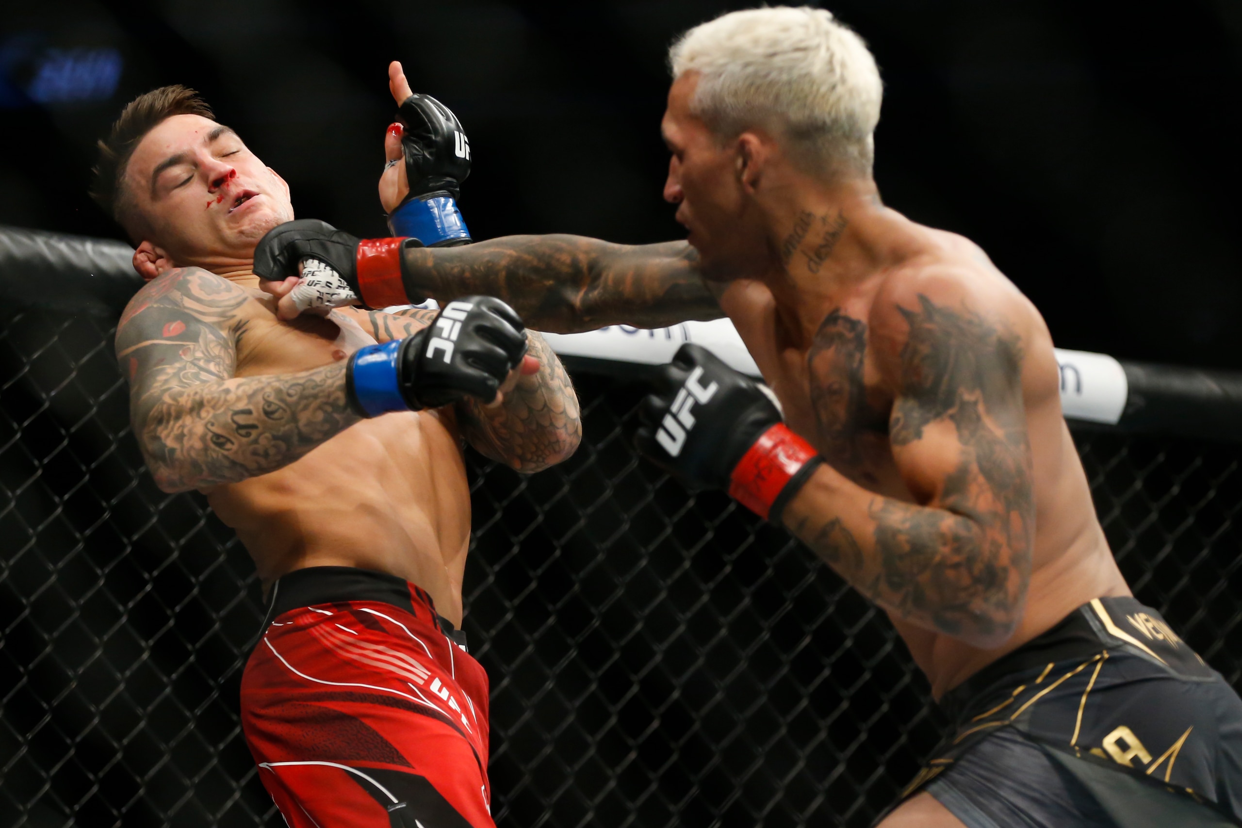 Charles Oliveira, right, lands a punch against Dustin Poirier during a lightweight mixed martial arts title bout at UFC 269, Saturday, Dec. 11, 2021, in Las Vegas. (AP Photo/Chase Stevens)