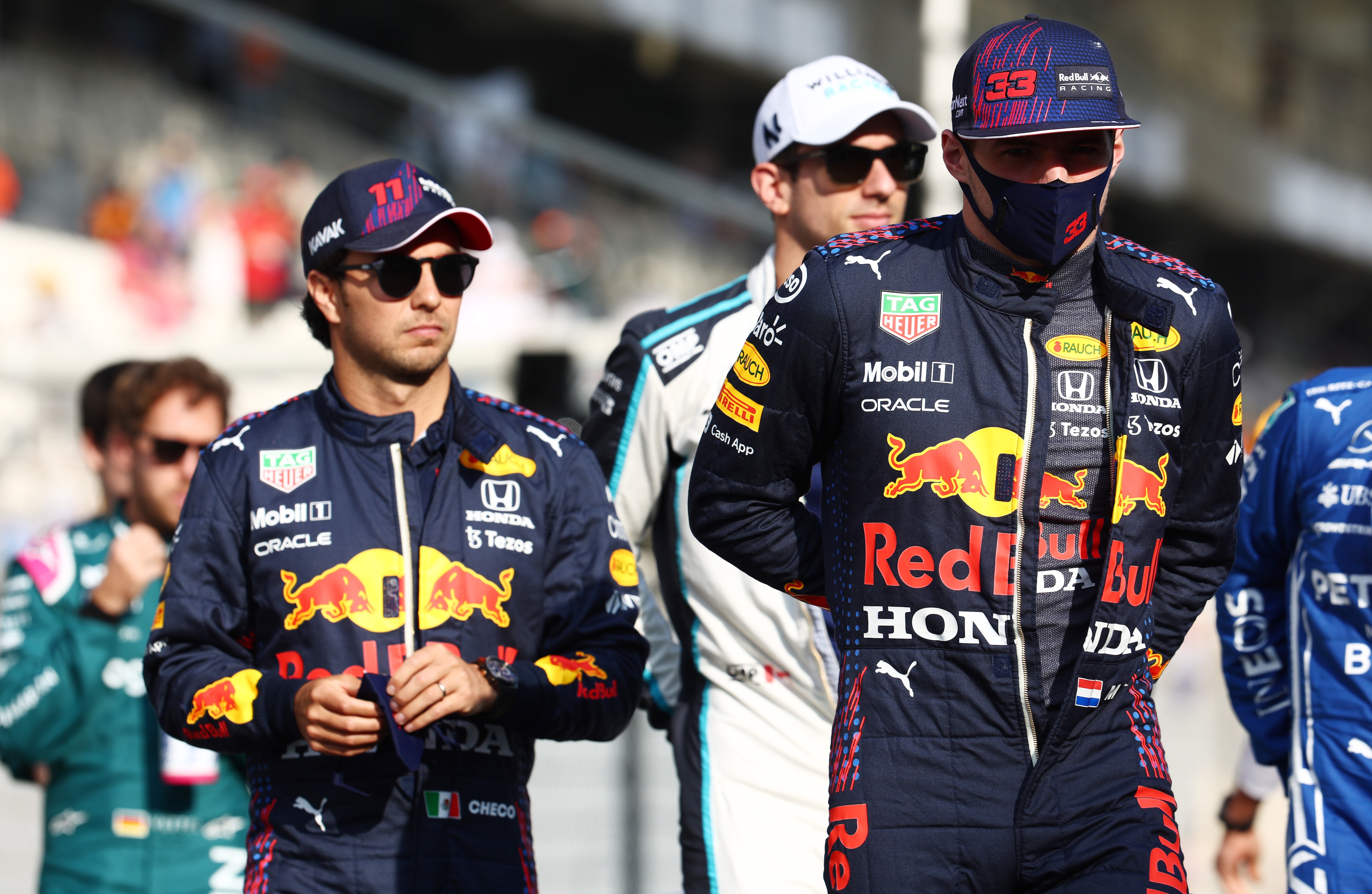 ABU DHABI, UNITED ARAB EMIRATES - DECEMBER 12: Max Verstappen of Netherlands and Red Bull Racing and Sergio Perez of Mexico and Red Bull Racing stand on the grid prior to the F1 Grand Prix of Abu Dhabi at Yas Marina Circuit on December 12, 2021 in Abu Dhabi, United Arab Emirates. (Photo by Mark Thompson/Getty Images)