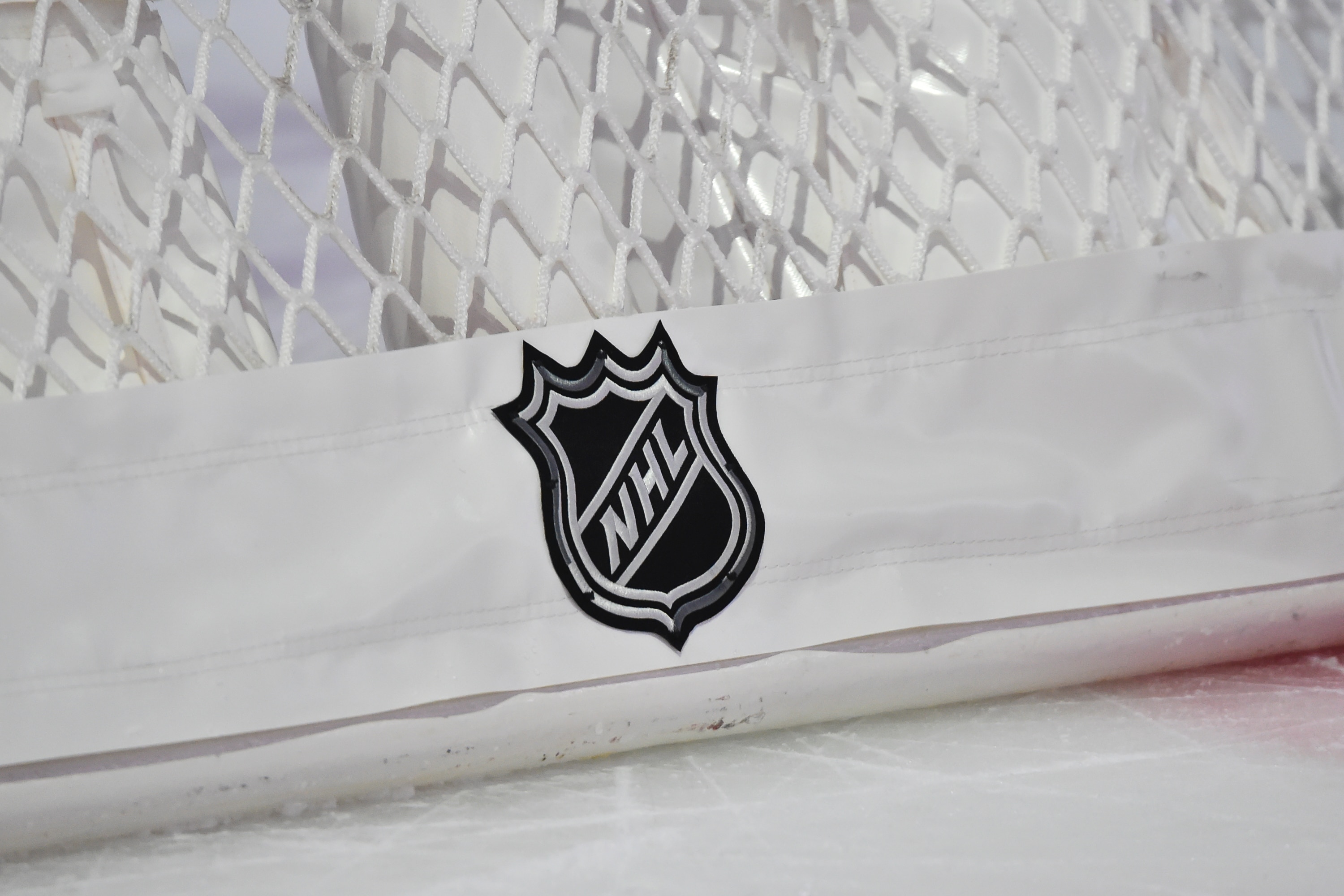 MONTREAL, QC - JANUARY 30: The NHL logo displayed behind a hockey net during intermission between the Montreal Canadiens and the Calgary Flames at the Bell Centre on January 30, 2021 in Montreal, Canada. The Calgary Flames defeated the Montreal Canadiens 2-0. (Photo by Minas Panagiotakis/Getty Images) MONTREAL, QC - JANUARY 30: The NHL logo displayed behind a hockey net during intermission between the Montreal Canadiens and the Calgary Flames at the Bell Centre on January 30, 2021 in Montreal, Canada. The Calgary Flames defeated the Montreal Canadiens 2-0. (Photo by Minas Panagiotakis/Getty Images)