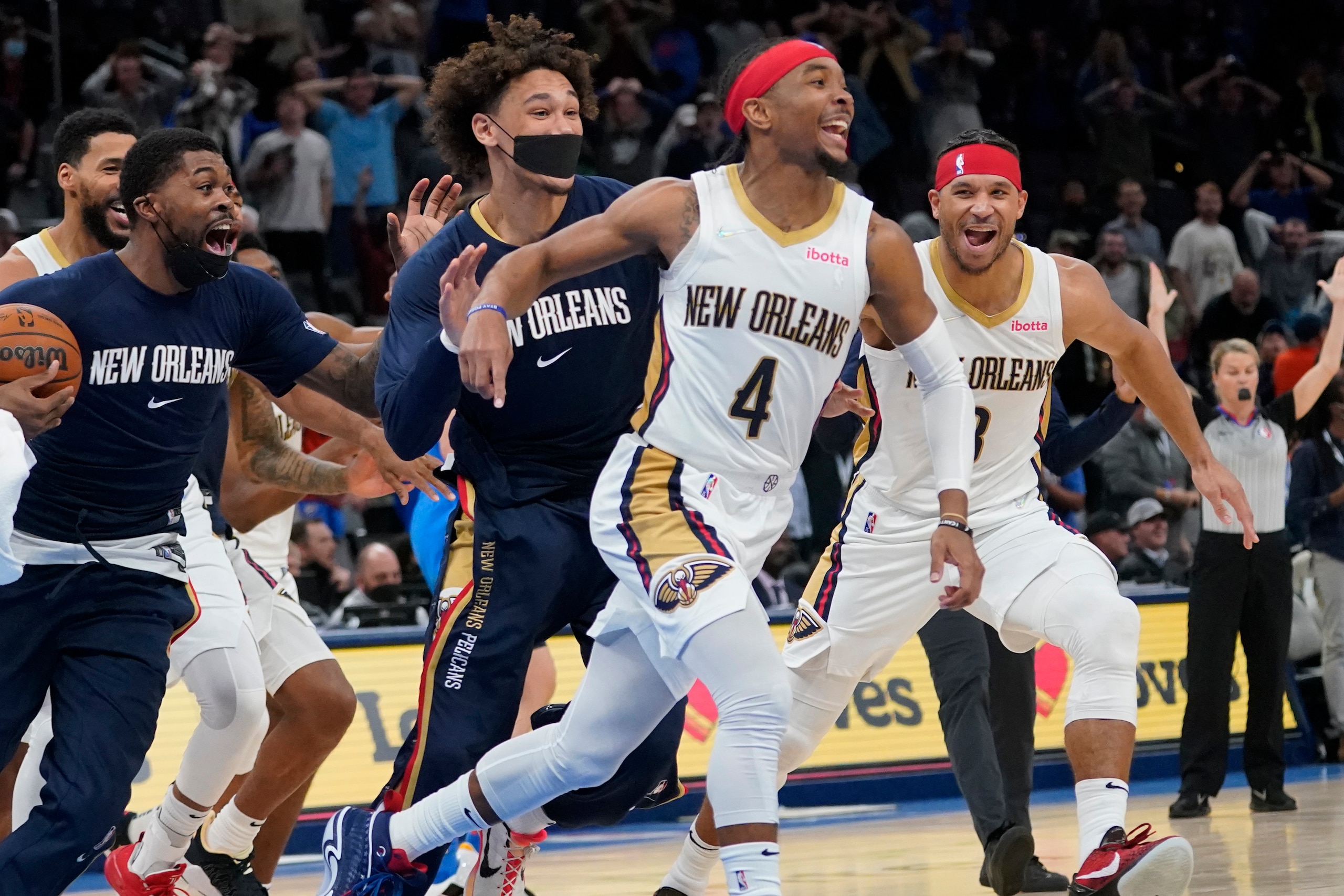 New Orleans Pelicans guard Devonte' Graham (4) celebrates with teammates after hitting the game winning basket to end the second half of an NBA basketball game against the Oklahoma City Thunder, Wednesday, Dec. 15, 2021, in Oklahoma City. (AP Photo/Sue Ogrocki)