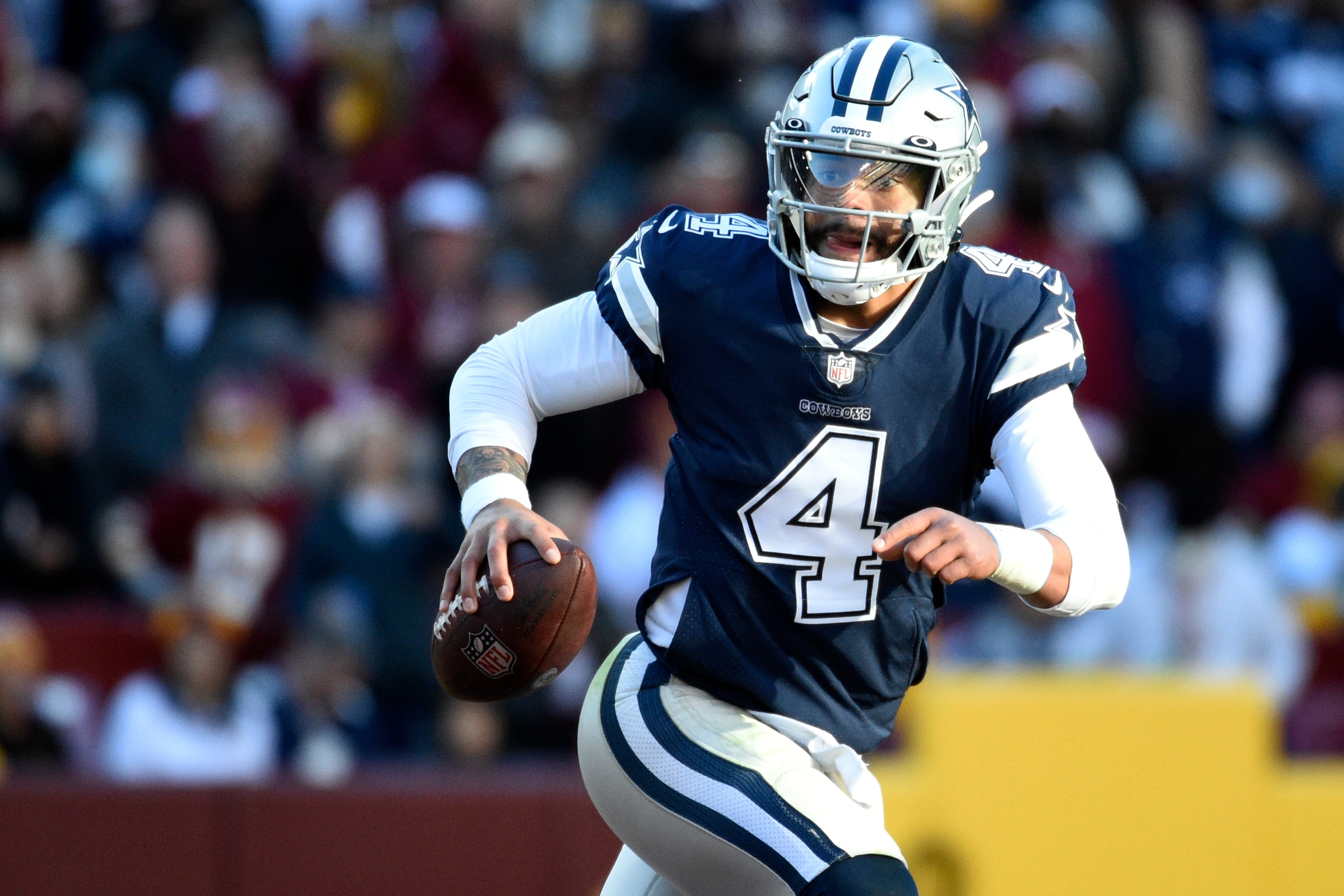 Dallas Cowboys quarterback Dak Prescott scrambles during an NFL football game against the Washington Football Team, Sunday, Dec. 12, 2021, in Landover, Md. (AP Photo/Mark Tenally)