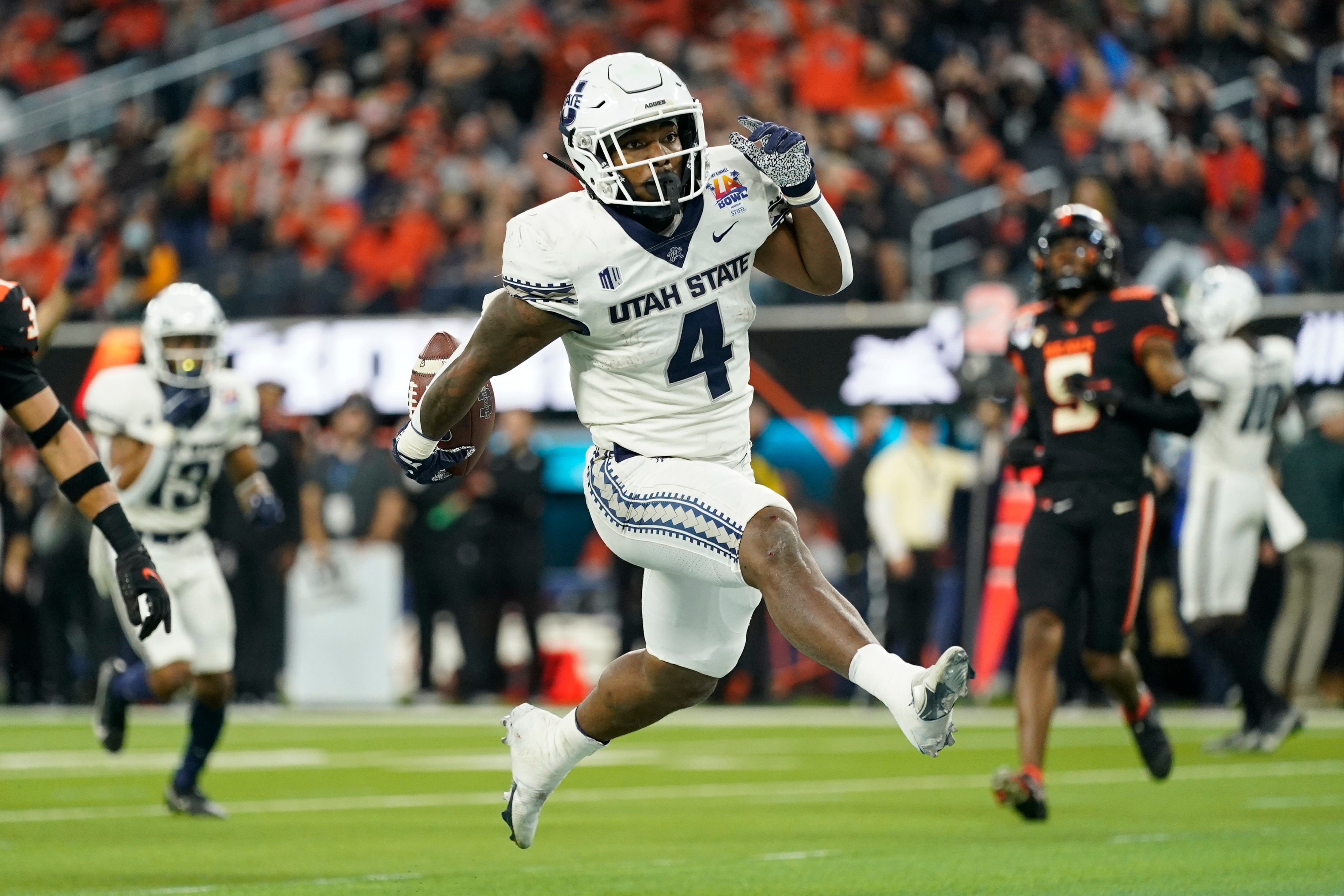 Utah State running back Calvin Tyler Jr. (4) runs to the end zone for a touchdown during the first half of the LA Bowl NCAA college football game against Oregon State in Inglewood, Calif., Saturday, Dec. 18, 2021. (AP Photo/Ashley Landis)