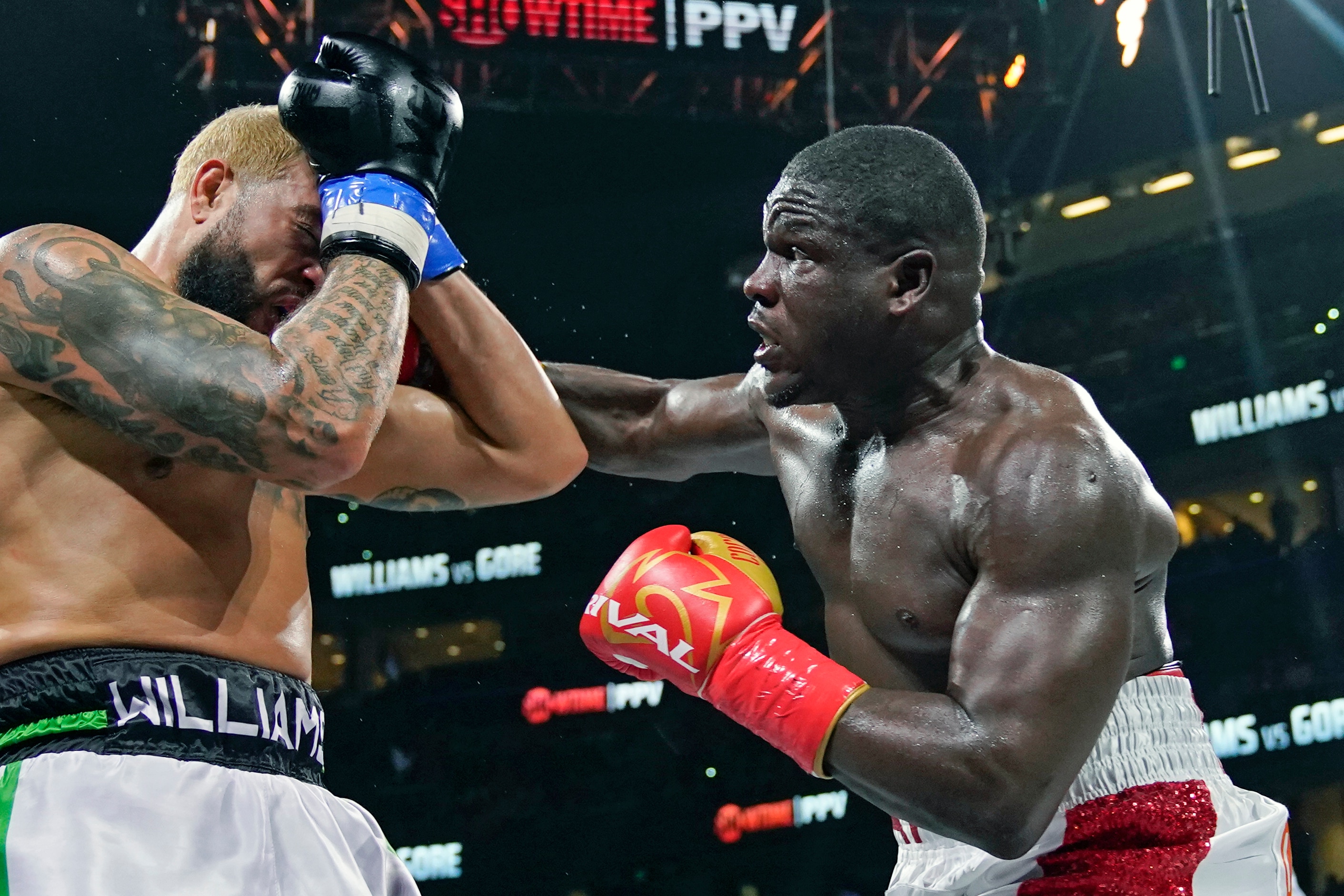 Frank Gore, right, lands a punch on Deron Williams during the fourth round of a heavyweight special attraction fight Saturday, Dec. 18, 2021, in Tampa, Fla. (AP Photo/Chris O'Meara)
