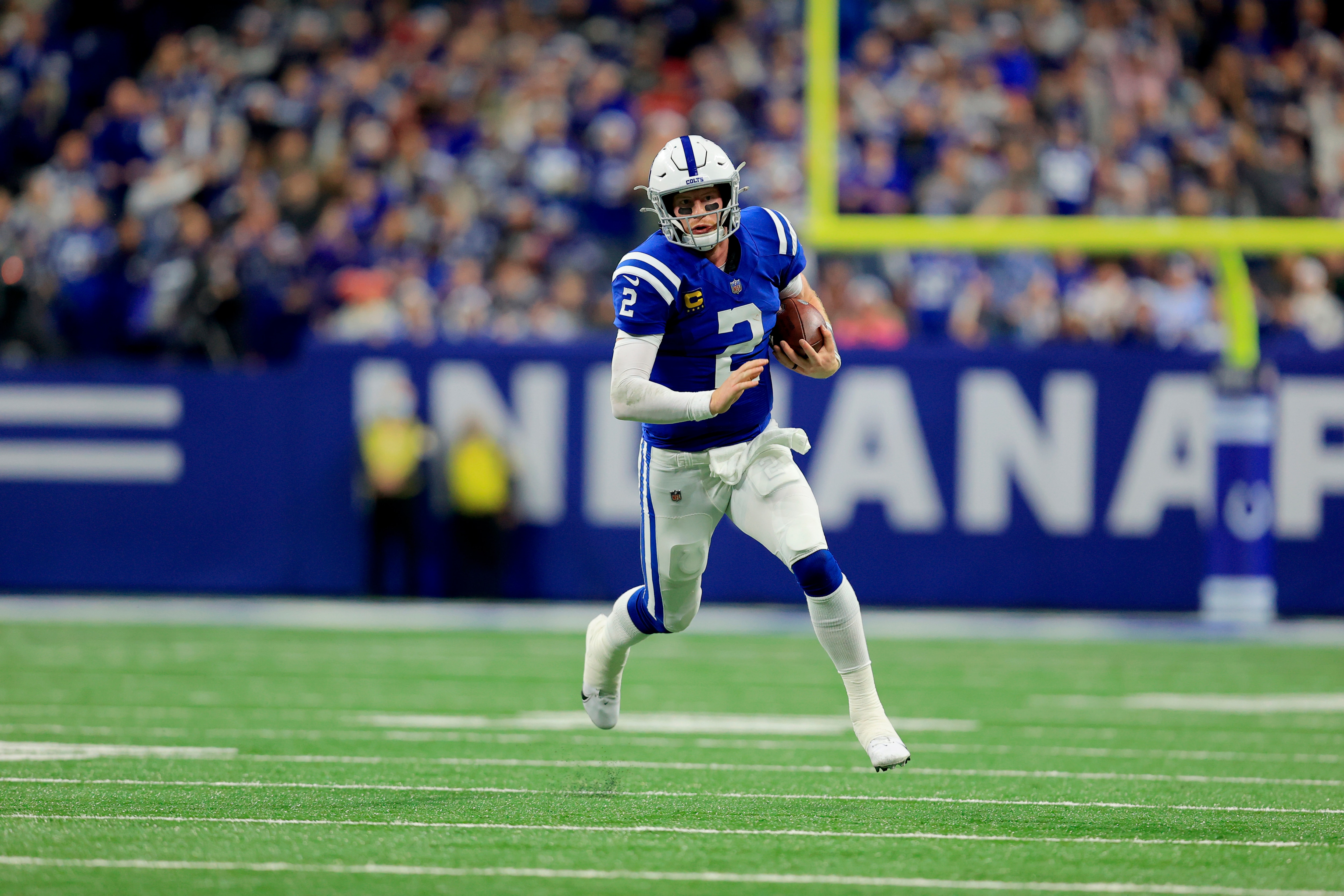 Indianapolis Colts quarterback Carson Wentz scrambles during the first half of an NFL football game against the New England Patriots Saturday, Dec. 18, 2021, in Indianapolis. (AP Photo/Aaron Doster)