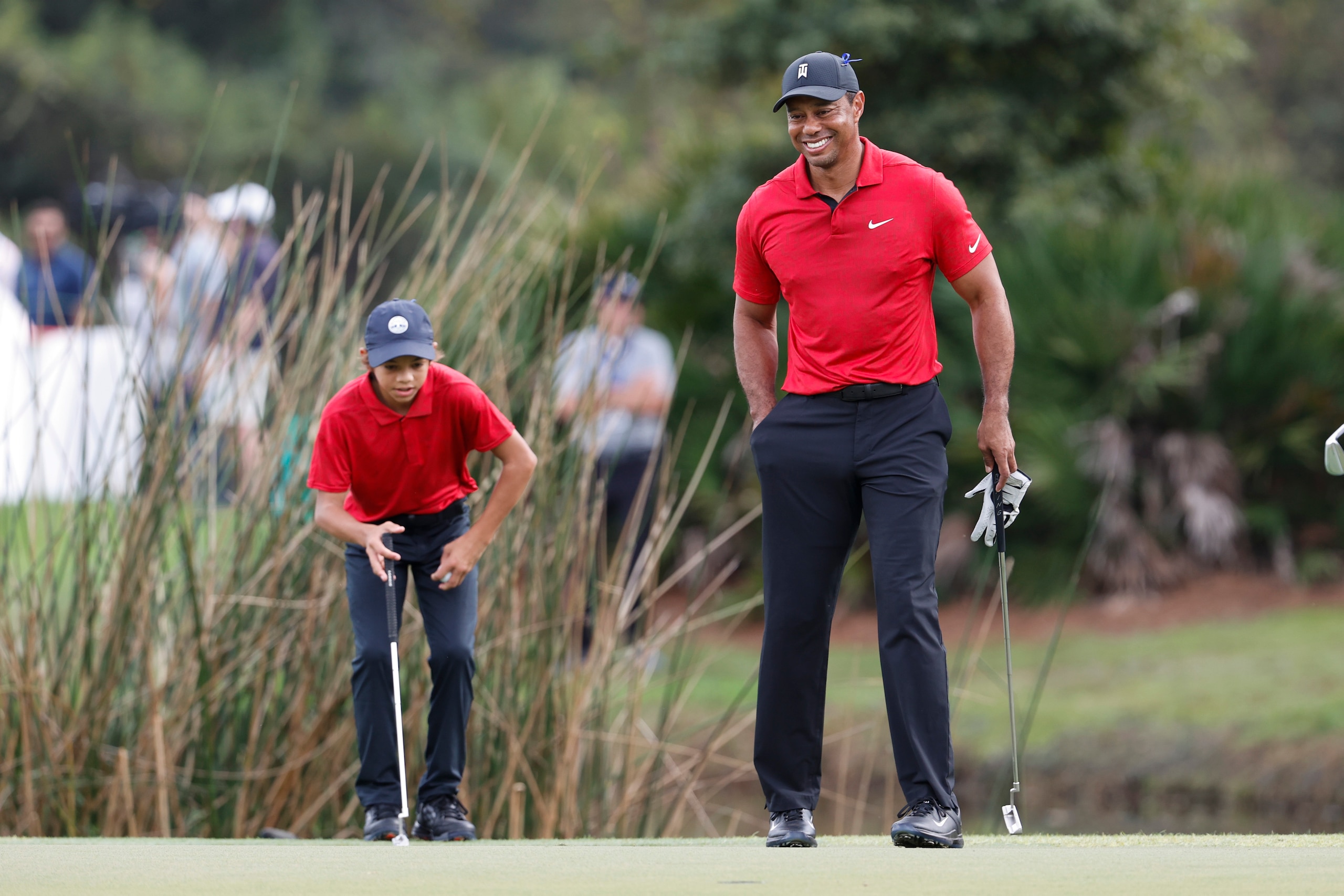 Tiger Woods smiles while walking on the second green during the second round of the PNC Championship golf tournament Sunday, Dec. 19, 2021, in Orlando, Fla. (AP Photo/Scott Audette)