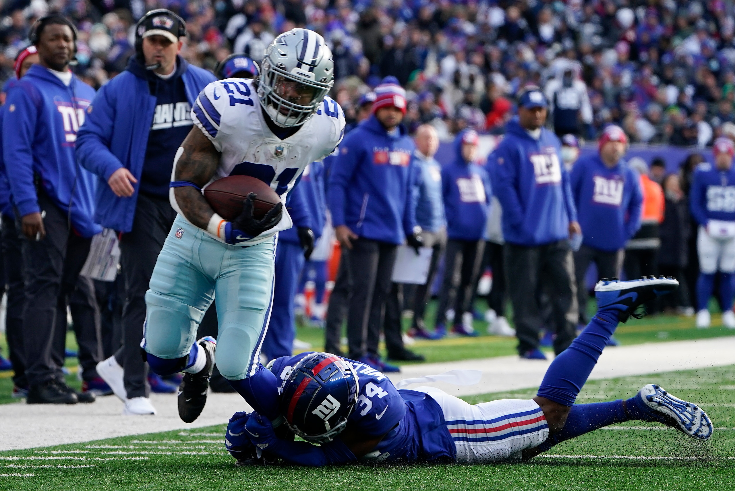 Dallas Cowboys running back Ezekiel Elliott (21) breaks free from New York Giants cornerback Jarren Williams (34) during the second quarter of an NFL football game, Sunday, Dec. 19, 2021, in East Rutherford, N.J. (AP Photo/Seth Wenig)