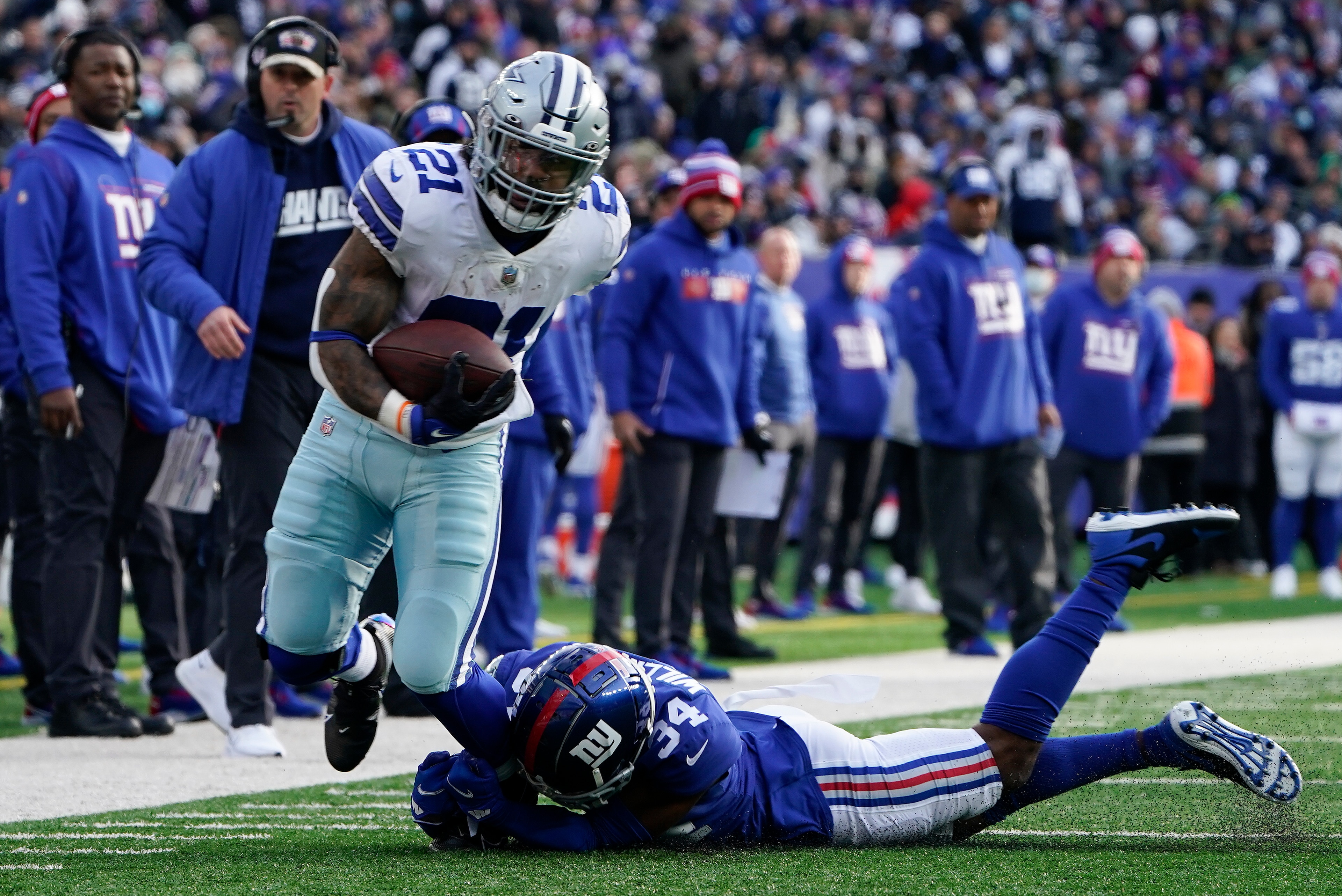 Dallas Cowboys running back Ezekiel Elliott (21) breaks free from New York Giants cornerback Jarren Williams (34) during the second quarter of an NFL football game, Sunday, Dec. 19, 2021, in East Rutherford, N.J. (AP Photo/Seth Wenig)