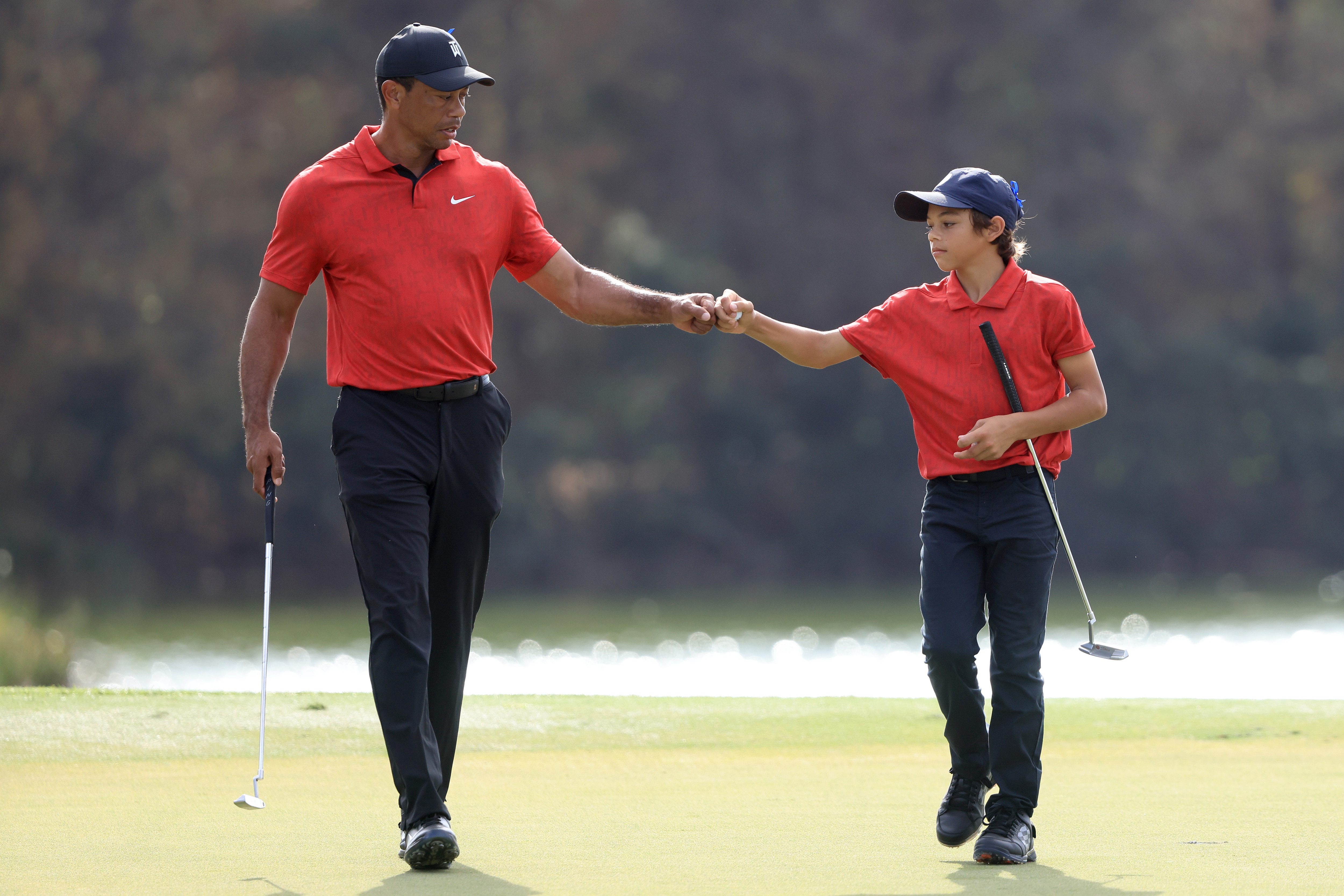 ORLANDO, FLORIDA - DECEMBER 19: Tiger Woods and Charlie Woods celebrate a birdie on the 13th hole during the final round of the PNC Championship at the Ritz Carlton Golf Club Grande Lakes   on December 19, 2021 in Orlando, Florida. (Photo by Sam Greenwood/Getty Images)