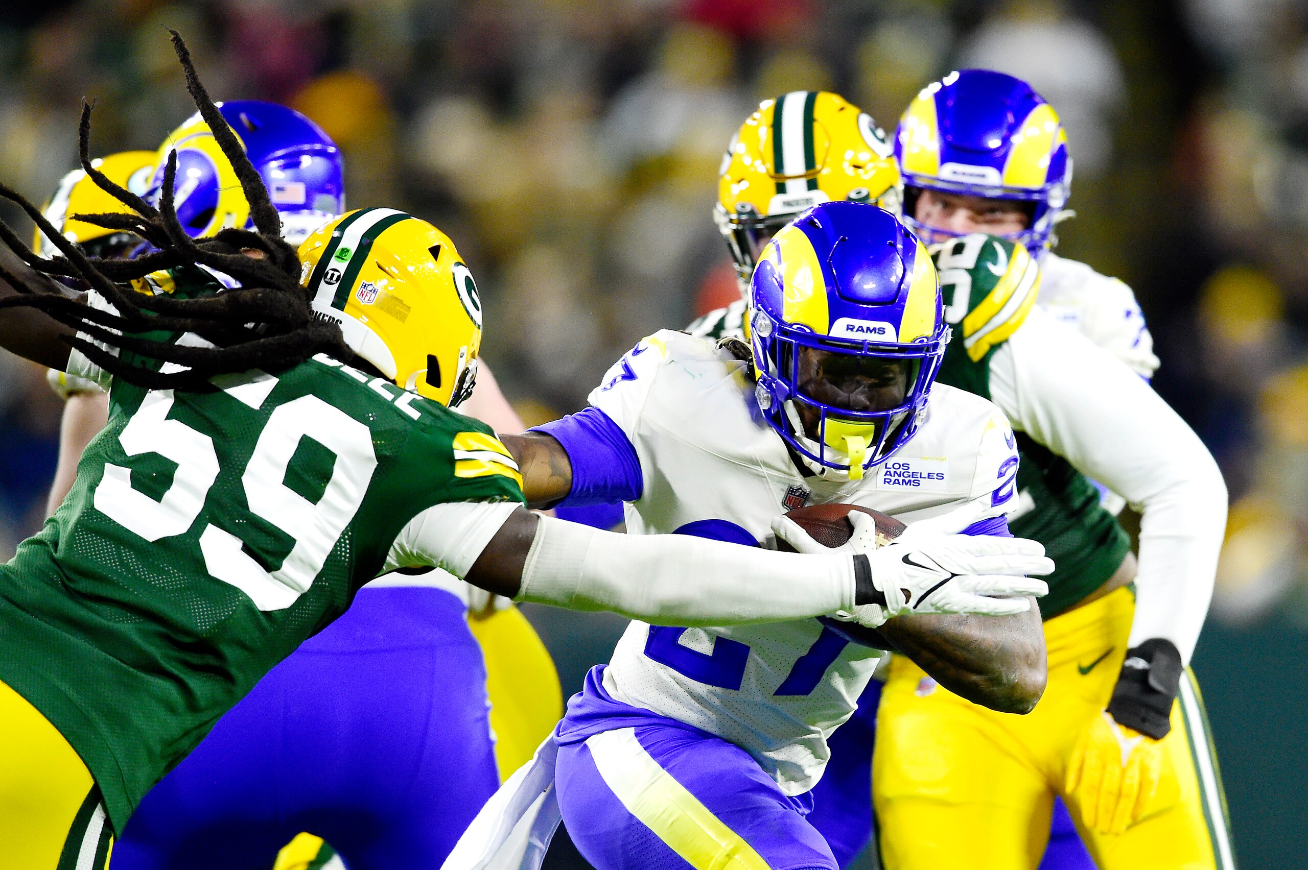 GREEN BAY, WISCONSIN - NOVEMBER 28: Darrell Henderson #27 of the Los Angeles Rams runs the ball and avoids a tackle by De'Vondre Campbell #59 of the Green Bay Packers during the first half at Lambeau Field on November 28, 2021 in Green Bay, Wisconsin. (Photo by Patrick McDermott/Getty Images)