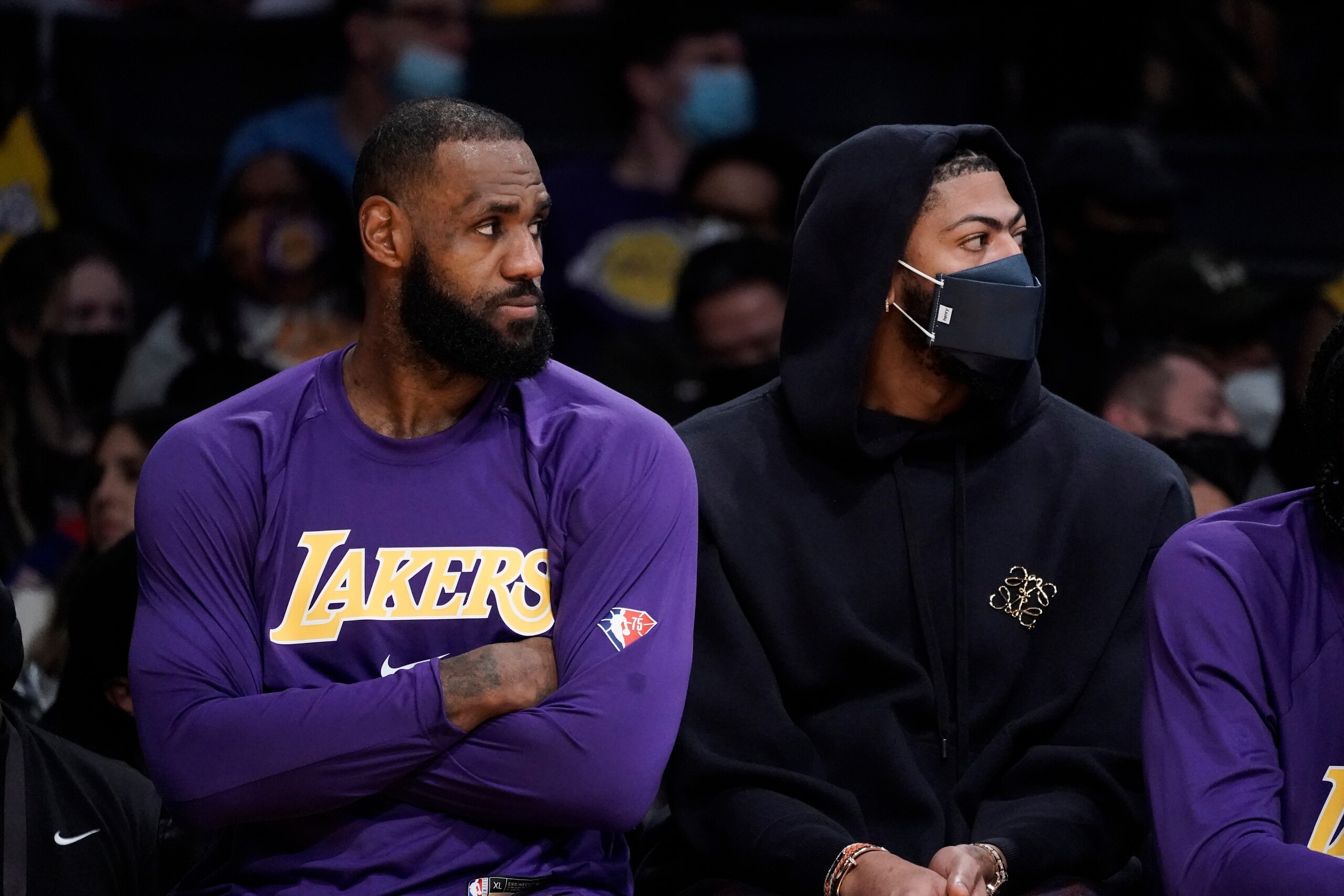 Los Angeles Lakers' LeBron James, left, and Anthony Davis watch from the bench during second half of the team's NBA basketball game against the Phoenix Suns on Tuesday, Dec. 21, 2021, in Los Angeles. The Suns won 108-90. (AP Photo/Jae C. Hong)