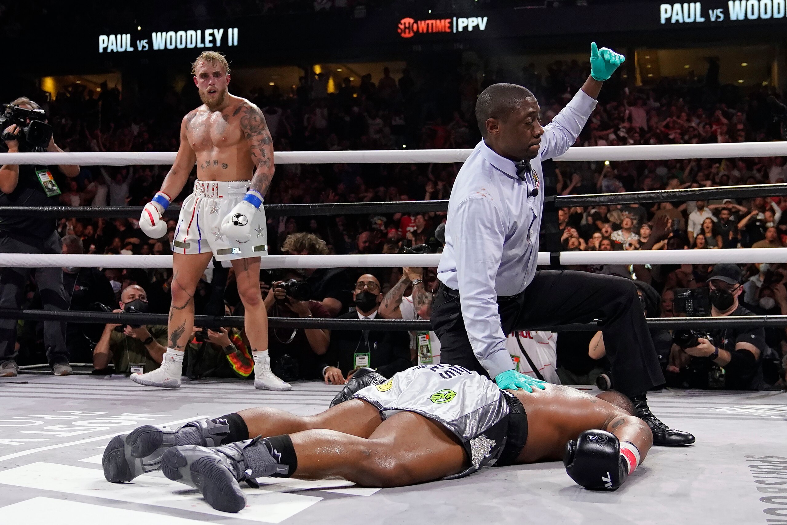 Jake Paul, left, knocks out Tyro Woodley during the sixth round of a Cruiserweight fight Sunday, Dec. 19, 2021, in Tampa, Fla. (AP Photo/Chris O'Meara)