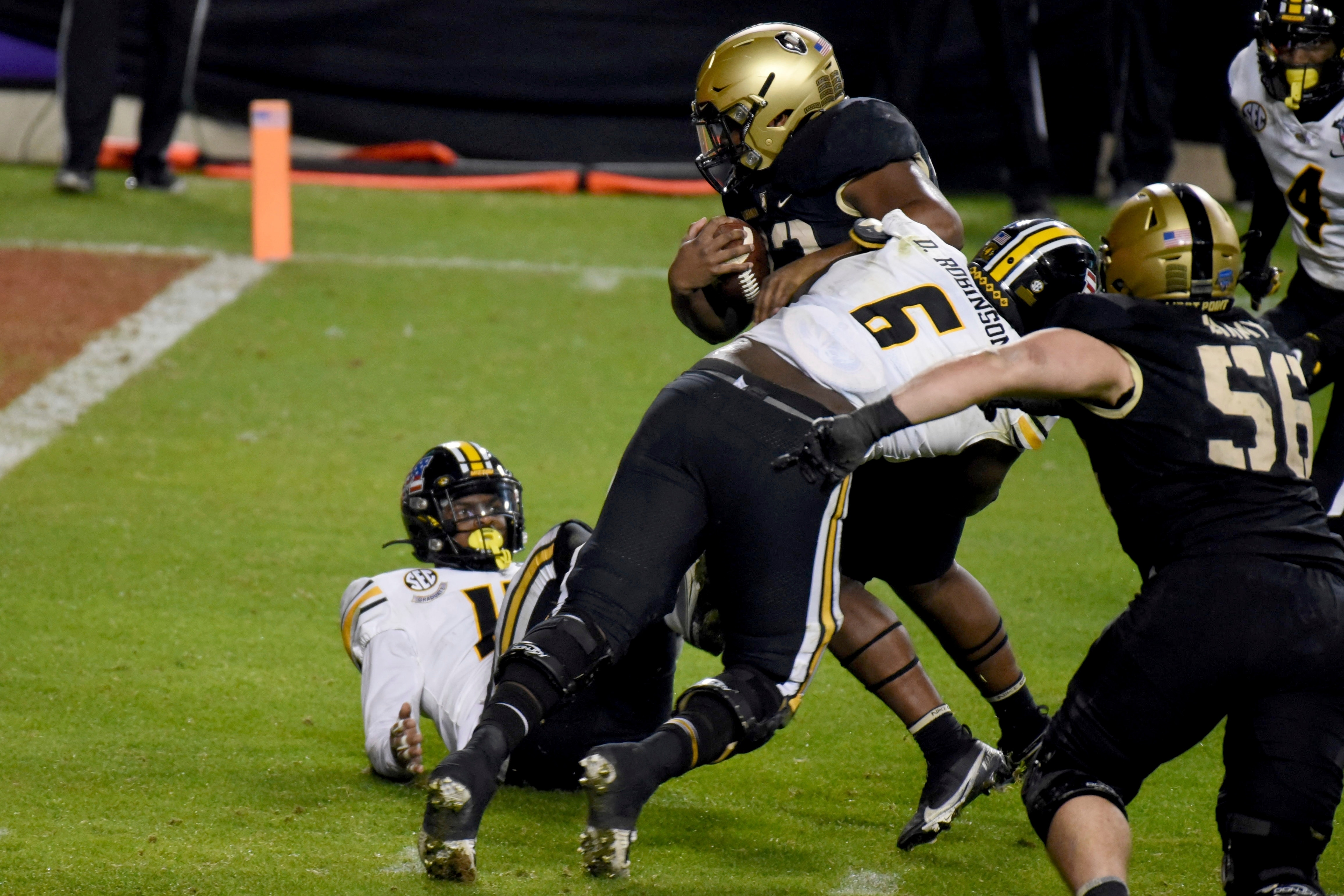 Missouri defensive lineman Darius Robinson (6) is unable to stop Army running back Jakobi Buchanan, center top, who reached the end zone for a touchdown on a running play in the second half of the Armed Forces Bowl NCAA college football game in Fort Worth, Texas, Wednesday, Dec. 22, 2021. (AP Photo/Emil Lippe)