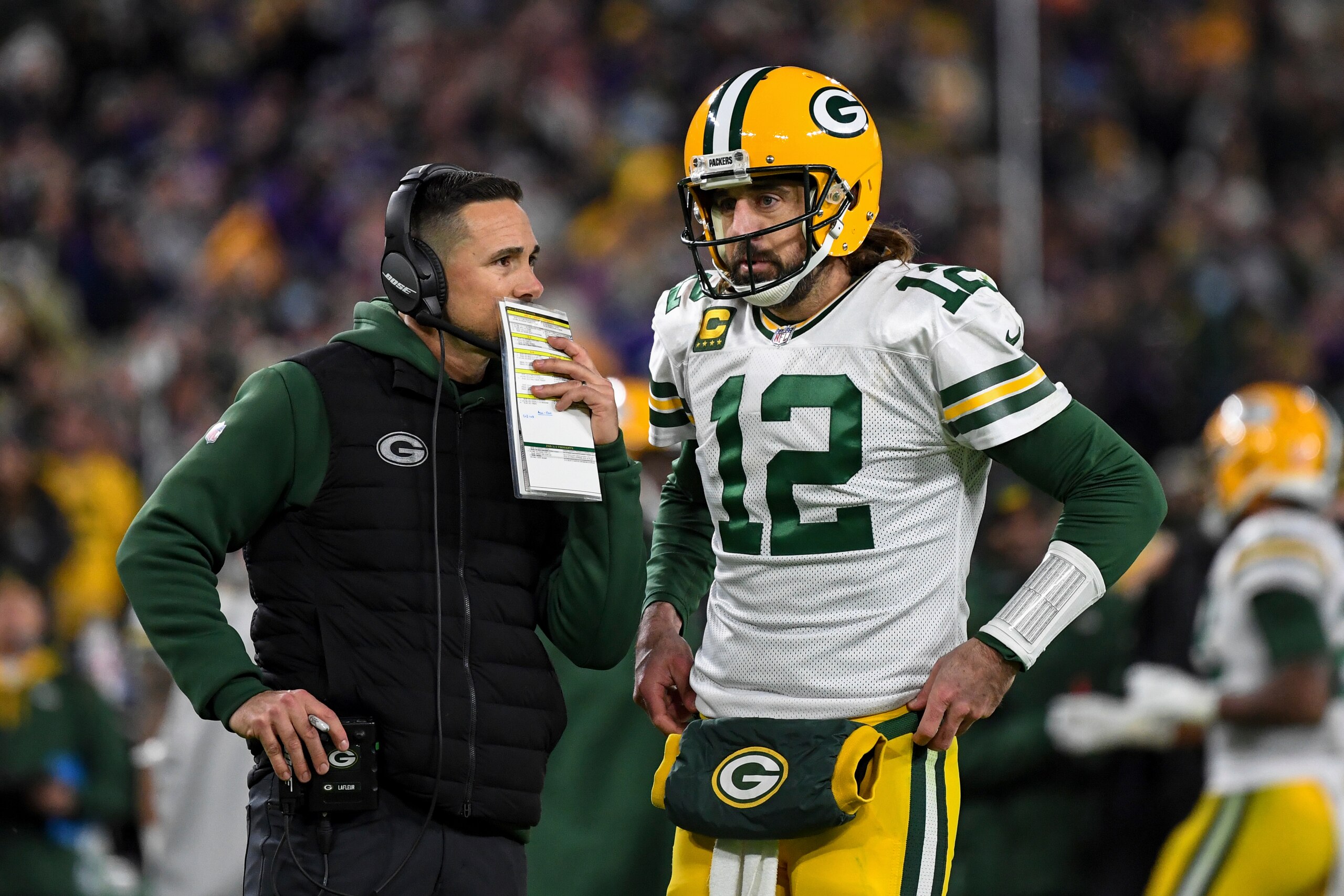 Green Bay Packers head coach Matt LaFleur talks with quarterback Aaron Rodgers (12) between plays during the second half of an NFL football game against the Baltimore Ravens, Sunday, Dec. 19, 2021, in Baltimore. (AP Photo/Terrance Williams)