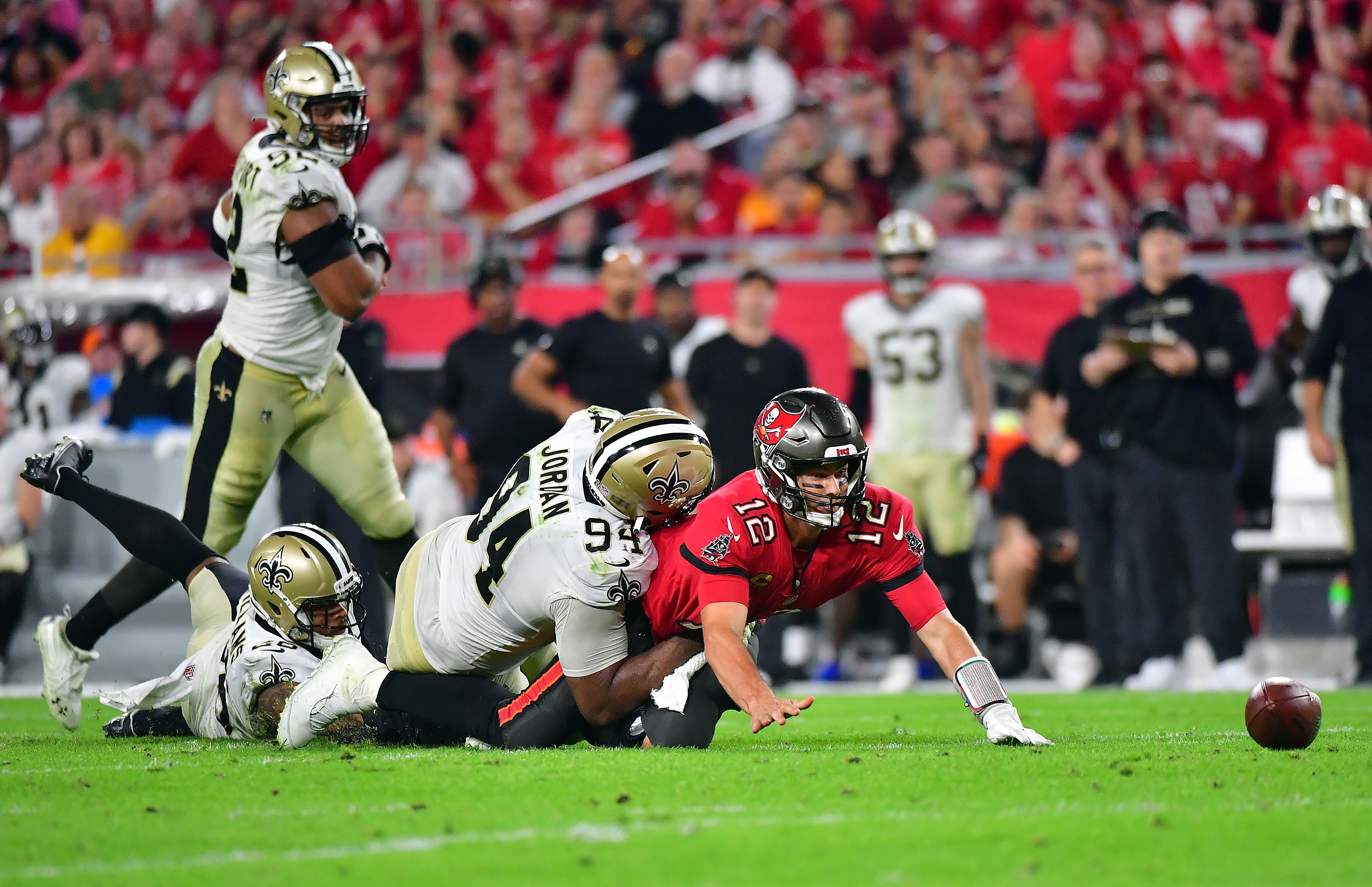 TAMPA, FLORIDA - DECEMBER 19:  Tom Brady #12 of the Tampa Bay Buccaneers fumbles the ball as he is hit by Cameron Jordan #94 of the New Orleans Saints during the 4th quarter of the game at Raymond James Stadium on December 19, 2021 in Tampa, Florida. (Photo by Julio Aguilar/Getty Images)