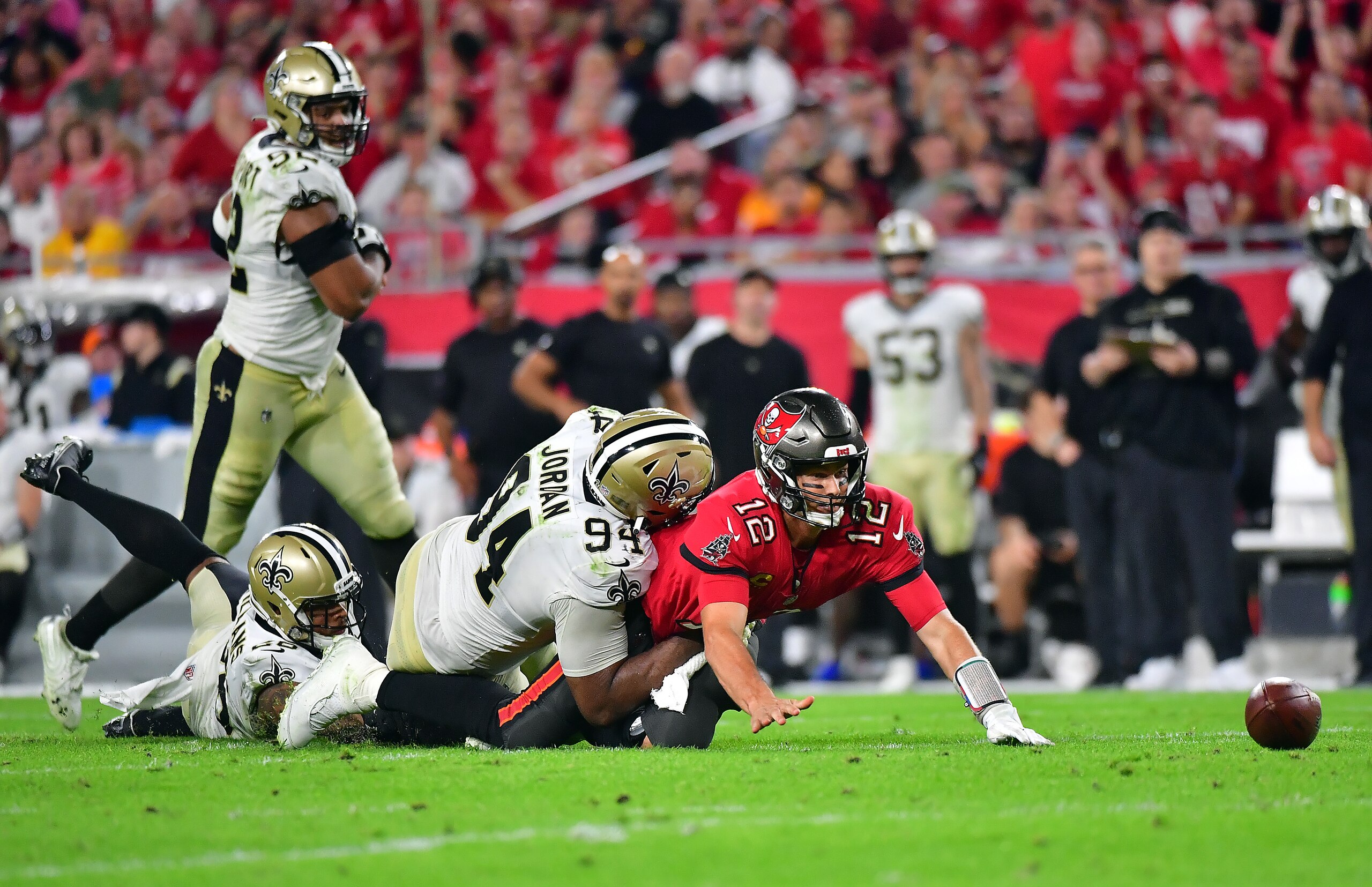 TAMPA, FLORIDA - DECEMBER 19:  Tom Brady #12 of the Tampa Bay Buccaneers fumbles the ball as he is hit by Cameron Jordan #94 of the New Orleans Saints during the 4th quarter of the game at Raymond James Stadium on December 19, 2021 in Tampa, Florida. (Photo by Julio Aguilar/Getty Images)