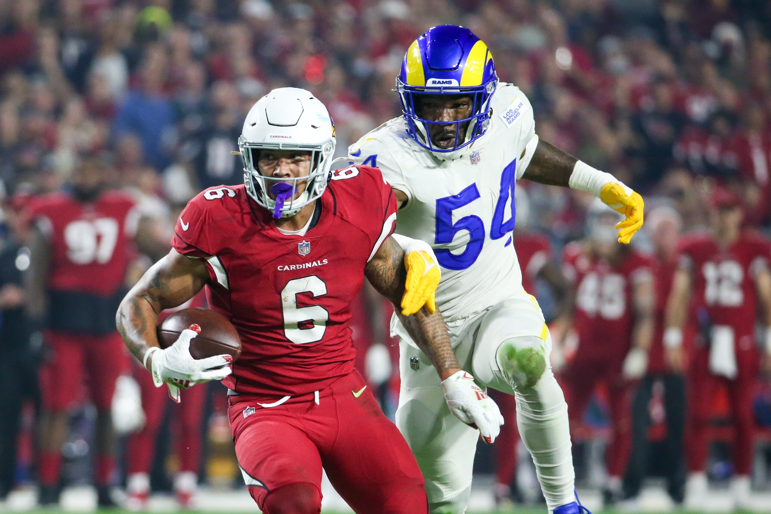 GLENDALE, AZ - DECEMBER 13 Arizona Cardinals running back James Conner #6 runs away from Los Angeles Rams outside linebacker Leonard Floyd #54 during the Los Angeles Rams vs Arizona Cardinals game on December 13, 2021, at State Farm Stadium in Glendale, AZ. (Photo by Jevone Moore/Icon Sportswire via Getty Images)