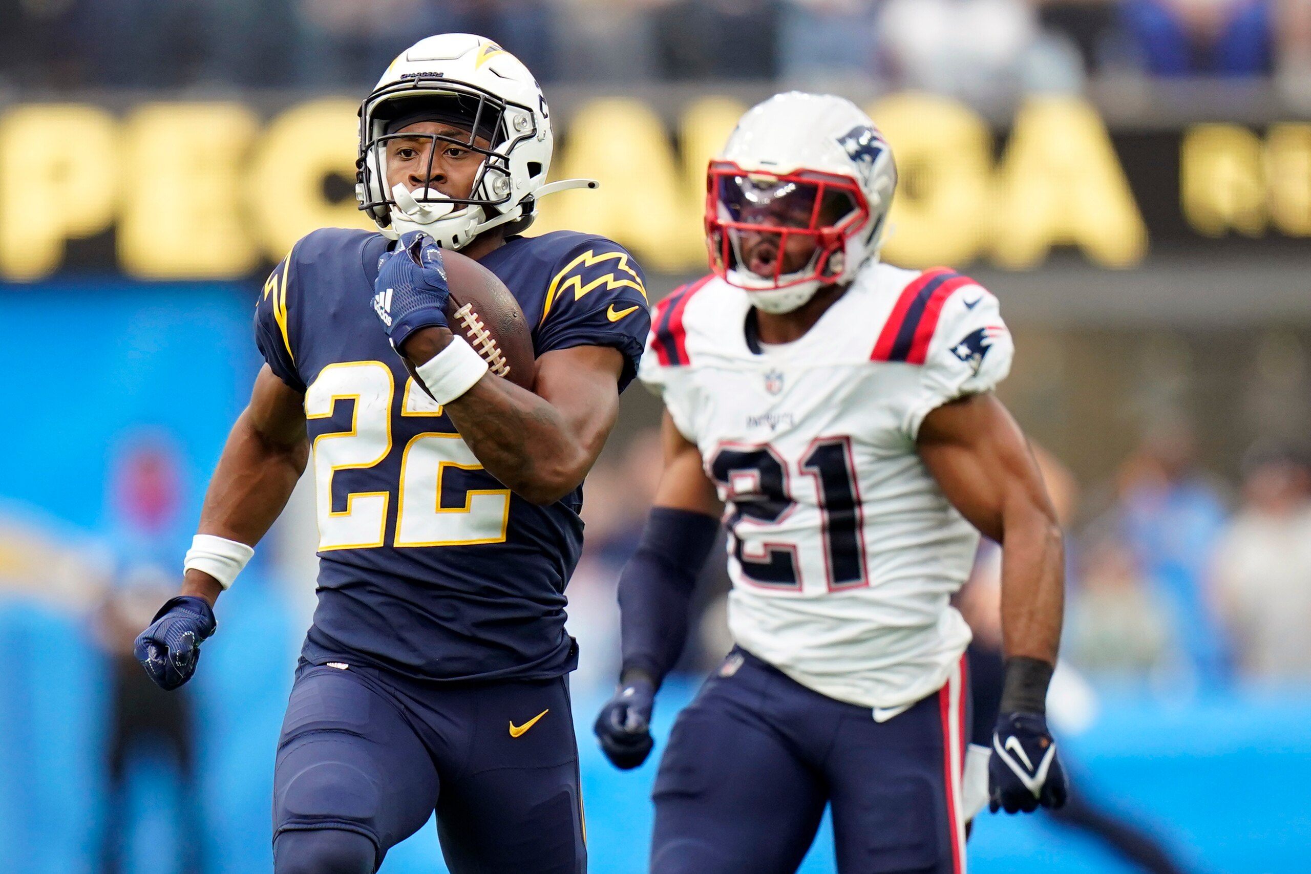 Los Angeles Chargers running back Justin Jackson (22) runs past New England Patriots safety Adrian Phillips (21) during the first half of an NFL football game Sunday, Oct. 31, 2021, in Inglewood, Calif. (AP Photo/Jae C. Hong)