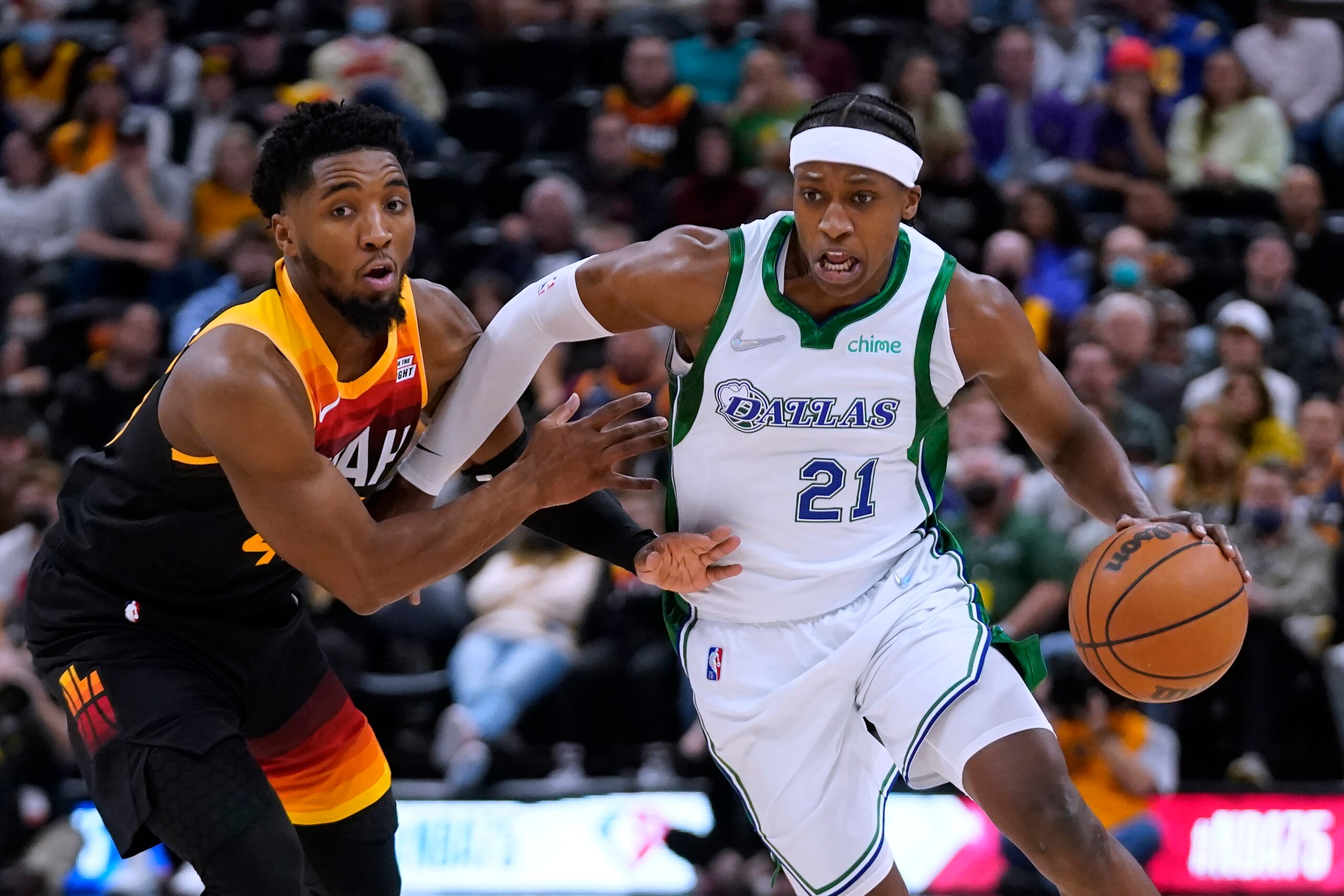 Dallas Mavericks guard Frank Ntilikina (21) drives against Utah Jazz's Donovan Mitchell during the first half of an NBA basketball game Saturday, Dec. 25, 2021, in Salt Lake City. (AP Photo/Rick Bowmer)