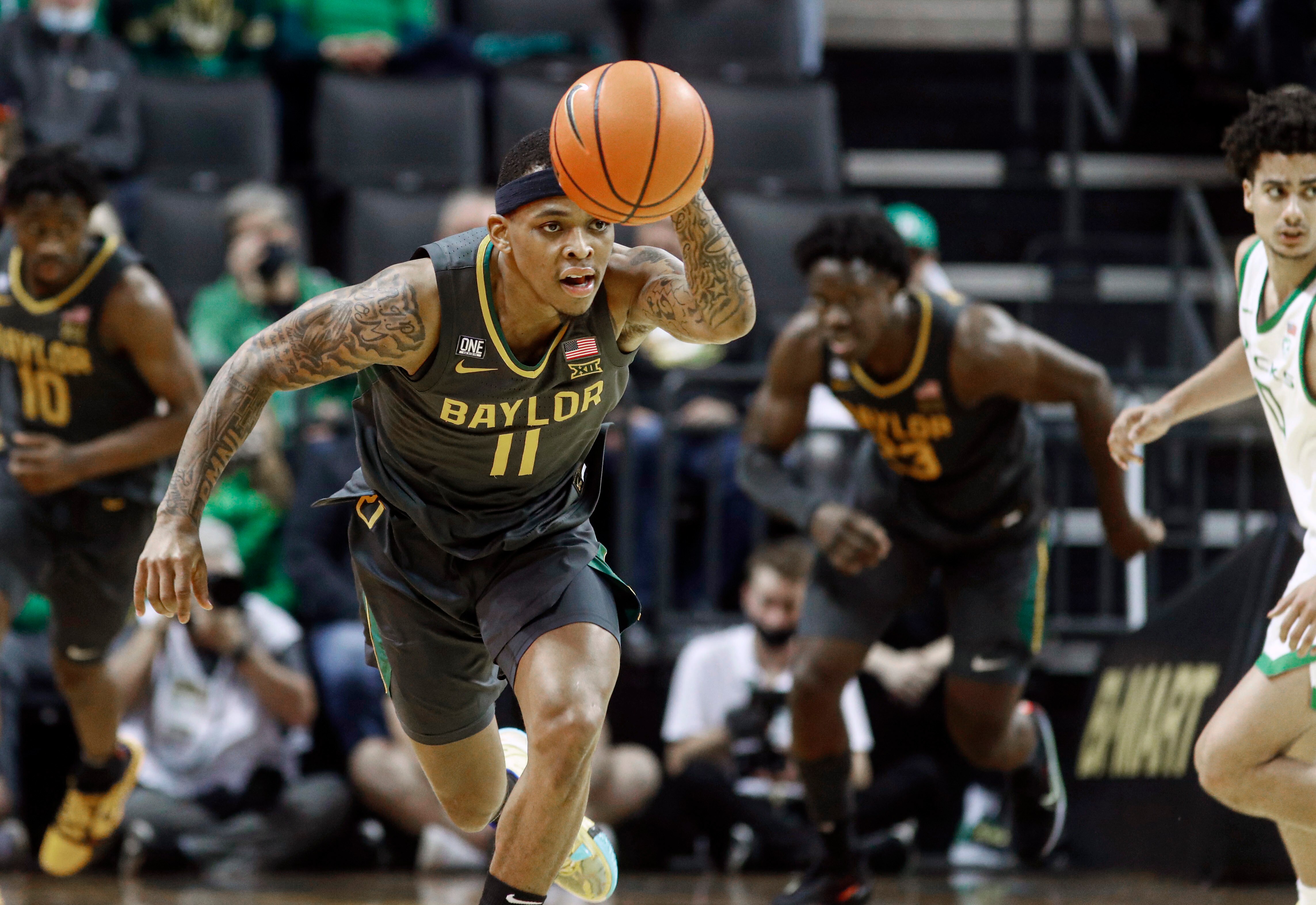 Baylor guard James Akinjo (11) takes the ball down court in the second half against Oregon during an NCAA college basketball game in Eugene, Ore., Saturday, Dec. 18, 2021. (AP Photo/Thomas Boyd)