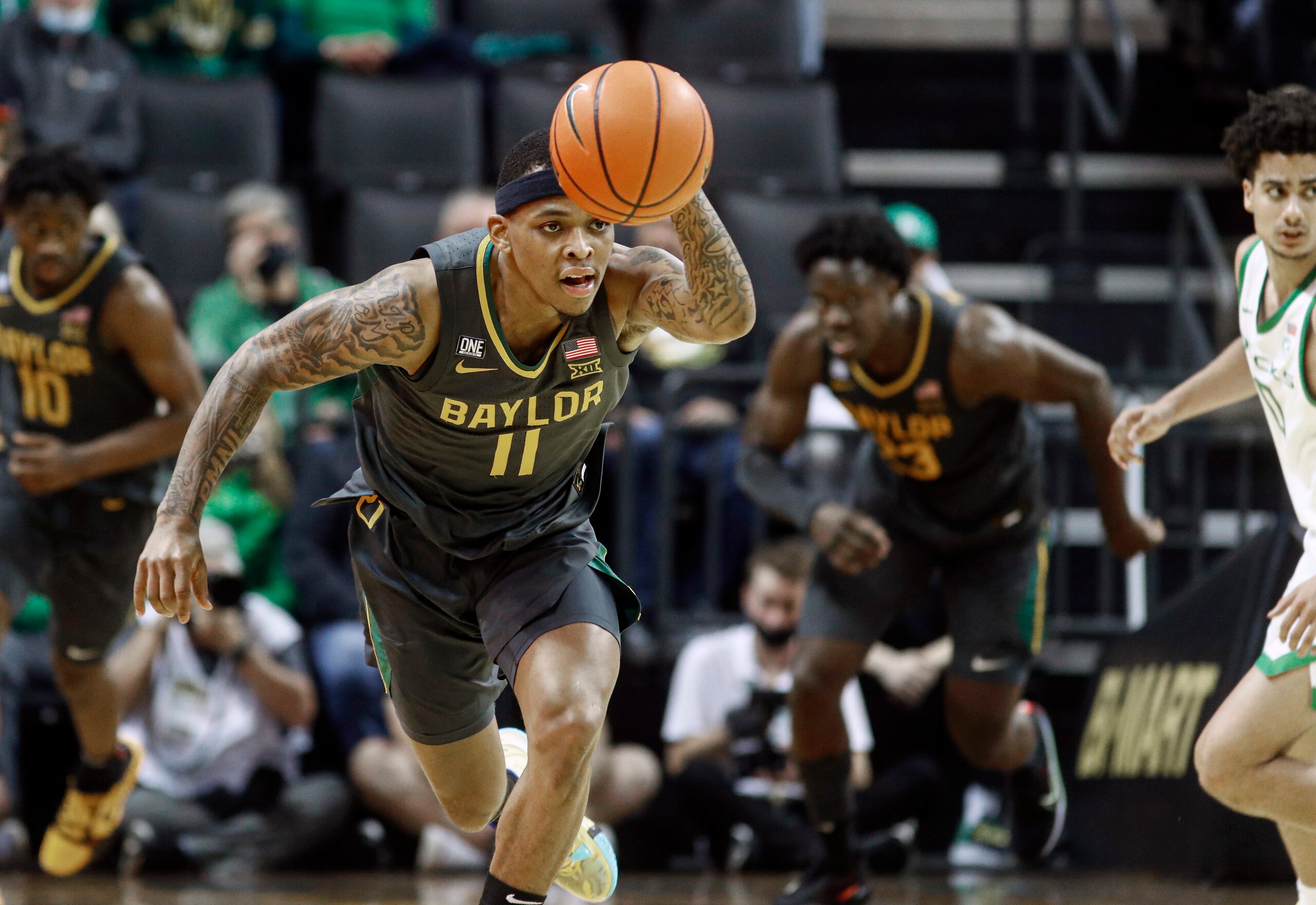 Baylor guard James Akinjo (11) takes the ball down court in the second half against Oregon during an NCAA college basketball game in Eugene, Ore., Saturday, Dec. 18, 2021. (AP Photo/Thomas Boyd)