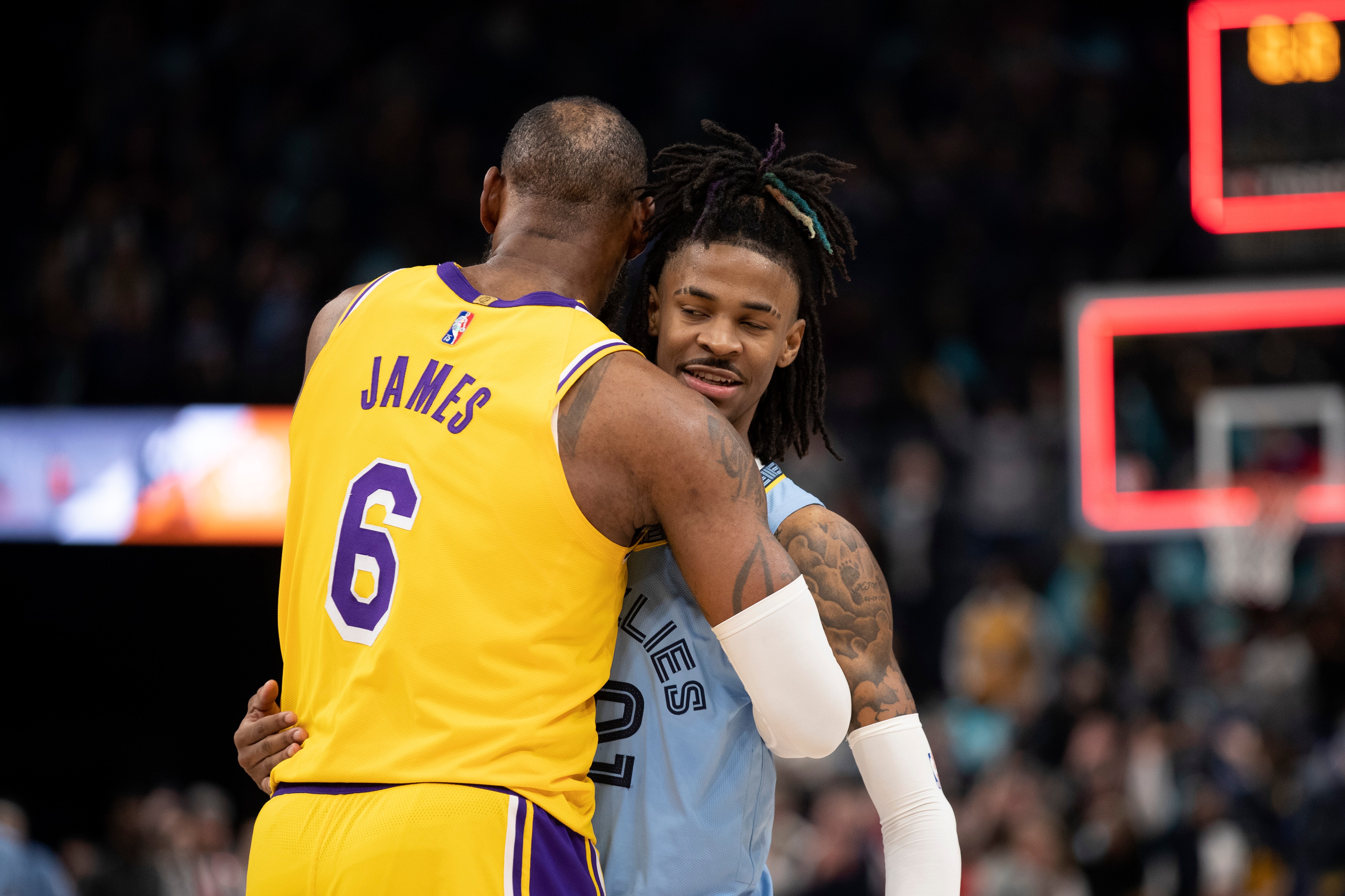 Los Angeles Lakers forward LeBron James (6) embraces Memphis Grizzlies guard Ja Morant (12) in the second half of an NBA basketball game Wednesday, Dec. 29, 2021, in Memphis, Tenn. (AP Photo/Nikki Boertman)