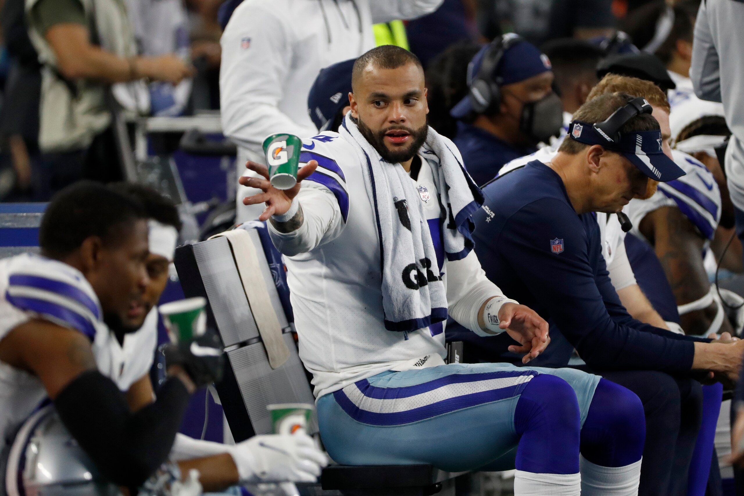 Dallas Cowboys quarterback Dak Prescott (4) throws a drink cup away during the first half of an NFL football game against the Washington Football Team in Arlington, Texas, Sunday, Dec. 26, 2021. (AP Photo/Roger Steinman)