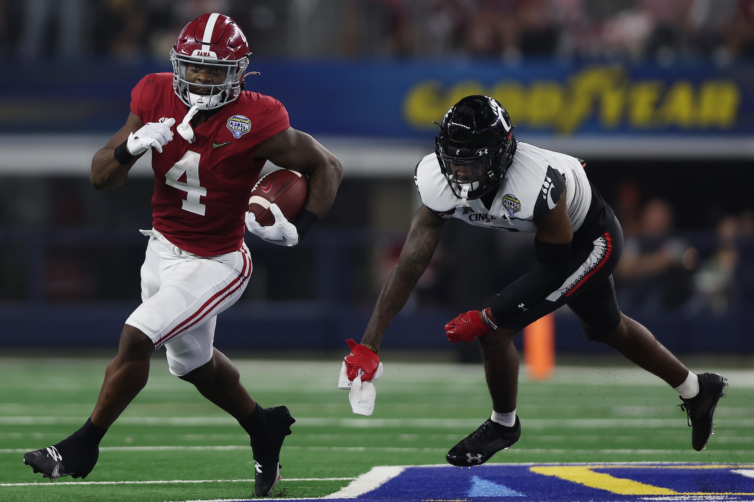 ARLINGTON, TEXAS - DECEMBER 31: Brian Robinson Jr. #4 of the Alabama Crimson Tide carries the ball past Ja'von Hicks #3 of the Cincinnati Bearcats during the first half in the Goodyear Cotton Bowl Classic for the College Football Playoff semifinal game at AT&T Stadium on December 31, 2021 in Arlington, Texas. (Photo by Matthew Stockman/Getty Images)