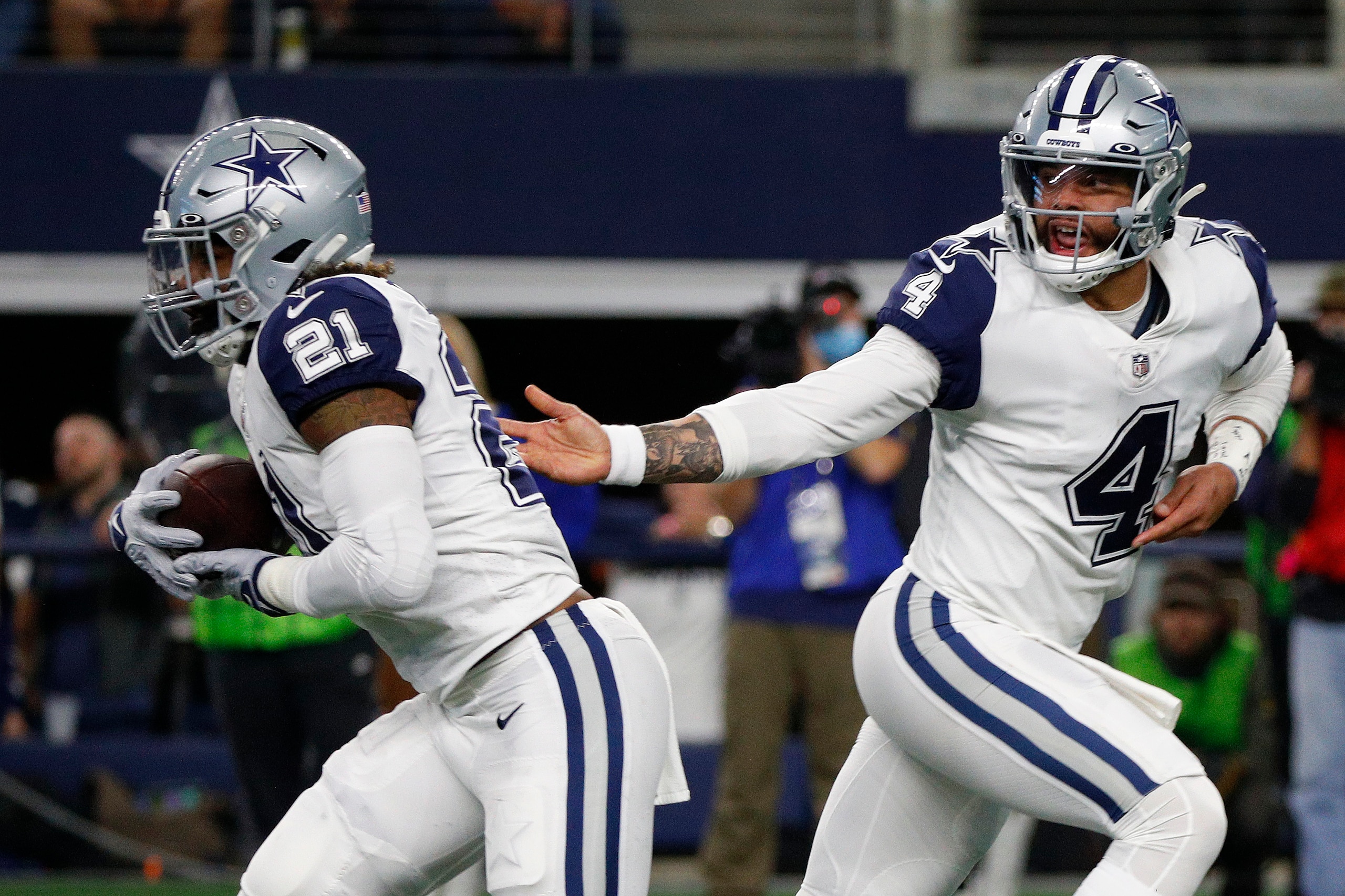 ARLINGTON, TEXAS - JANUARY 02: Dak Prescott #4 of the Dallas Cowboys hands the ball to Ezekiel Elliott #21 during the second quarter against the Arizona Cardinals at AT&T Stadium on January 02, 2022 in Arlington, Texas. (Photo by Richard Rodriguez/Getty Images)