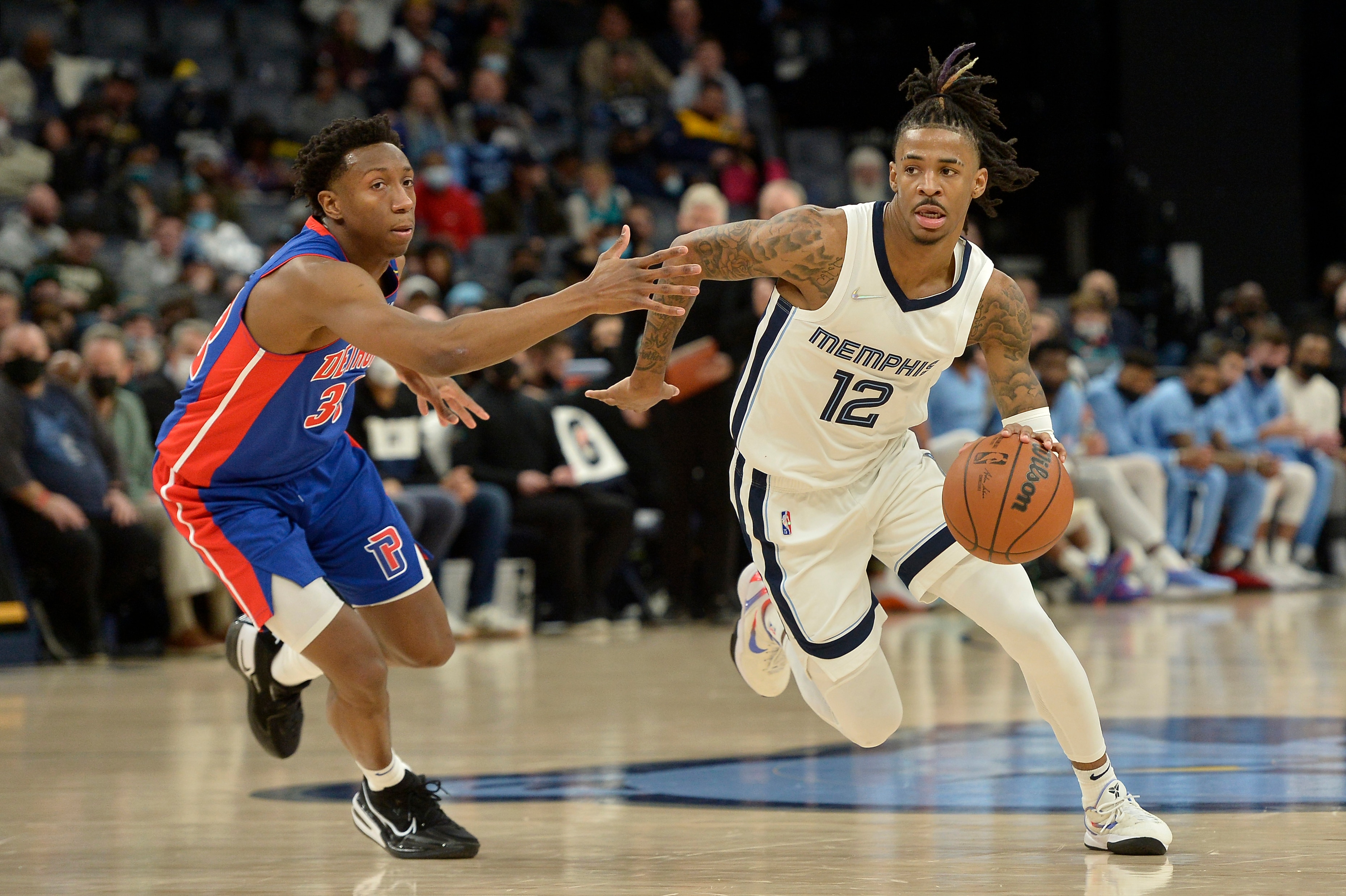 Ja Morant (12), de los Grizzlies de Memphis, conduce el balón frente a Saben Lee (38), de los Pistons de Detroit, en la segunda mitad del partido de la NBA en Memphis, Tennessee, el jueves 6 de enero de 2022. (AP Foto/Brandon Dill)