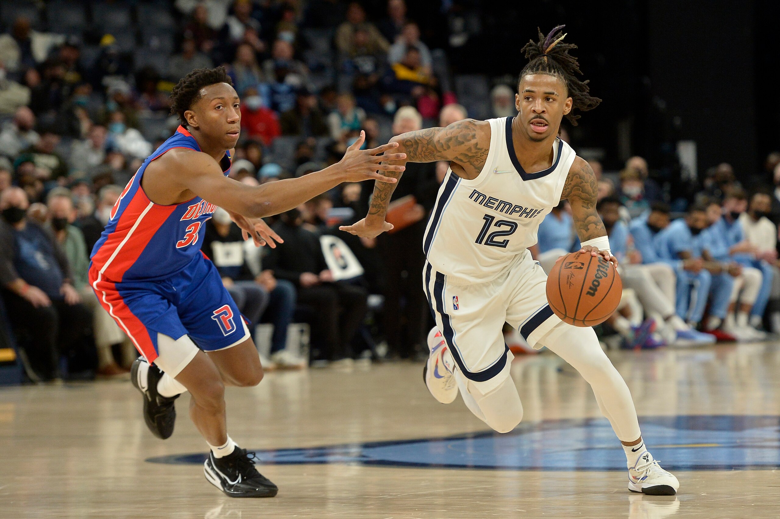 Ja Morant (12), de los Grizzlies de Memphis, conduce el balón frente a Saben Lee (38), de los Pistons de Detroit, en la segunda mitad del partido de la NBA en Memphis, Tennessee, el jueves 6 de enero de 2022. (AP Foto/Brandon Dill)