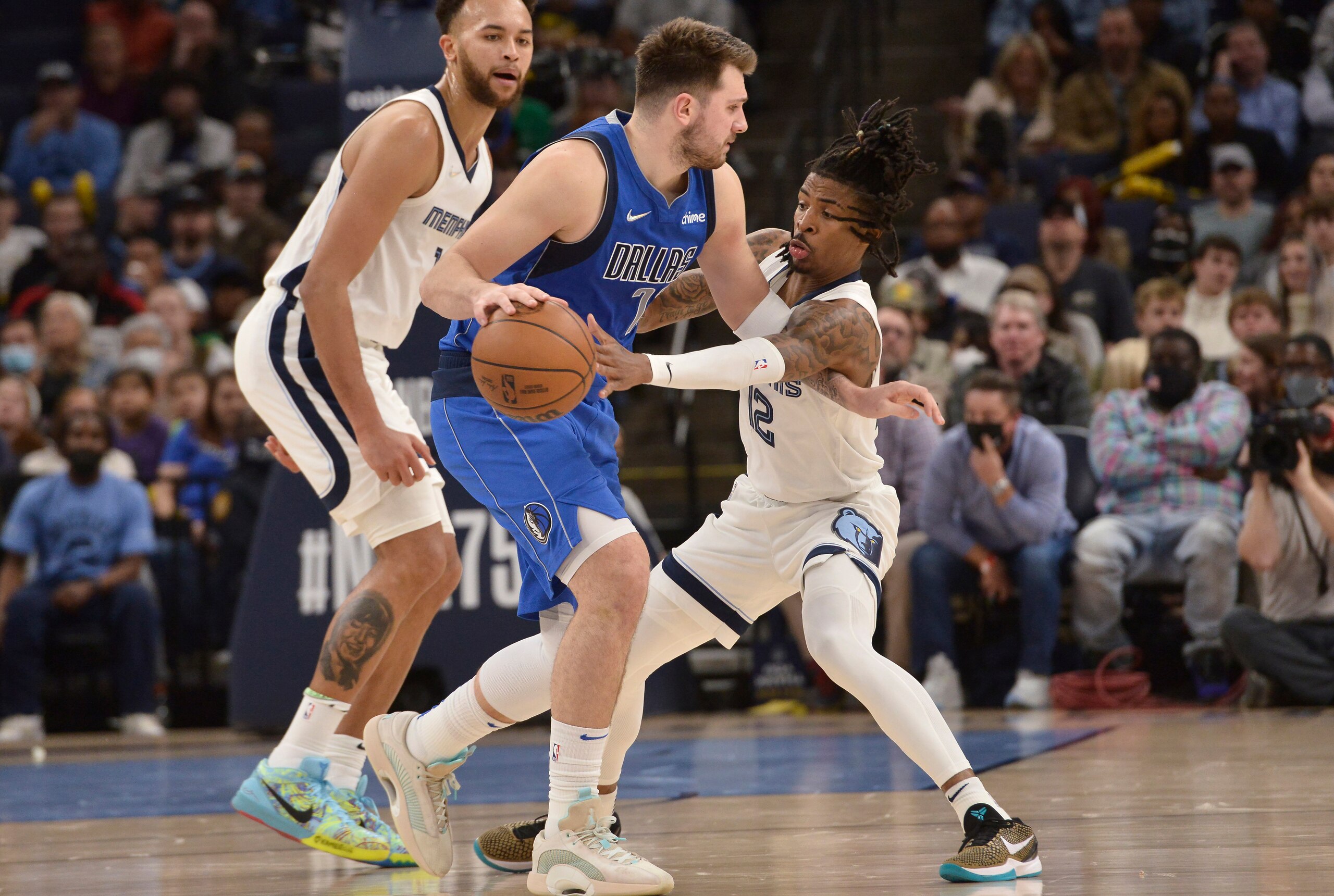 Dallas Mavericks guard Luka Doncic (77) handles the ball against Memphis Grizzlies guard Ja Morant (12) in the first half of an NBA basketball game Friday, Jan. 14, 2022, in Memphis, Tenn. (AP Photo/Brandon Dill)
