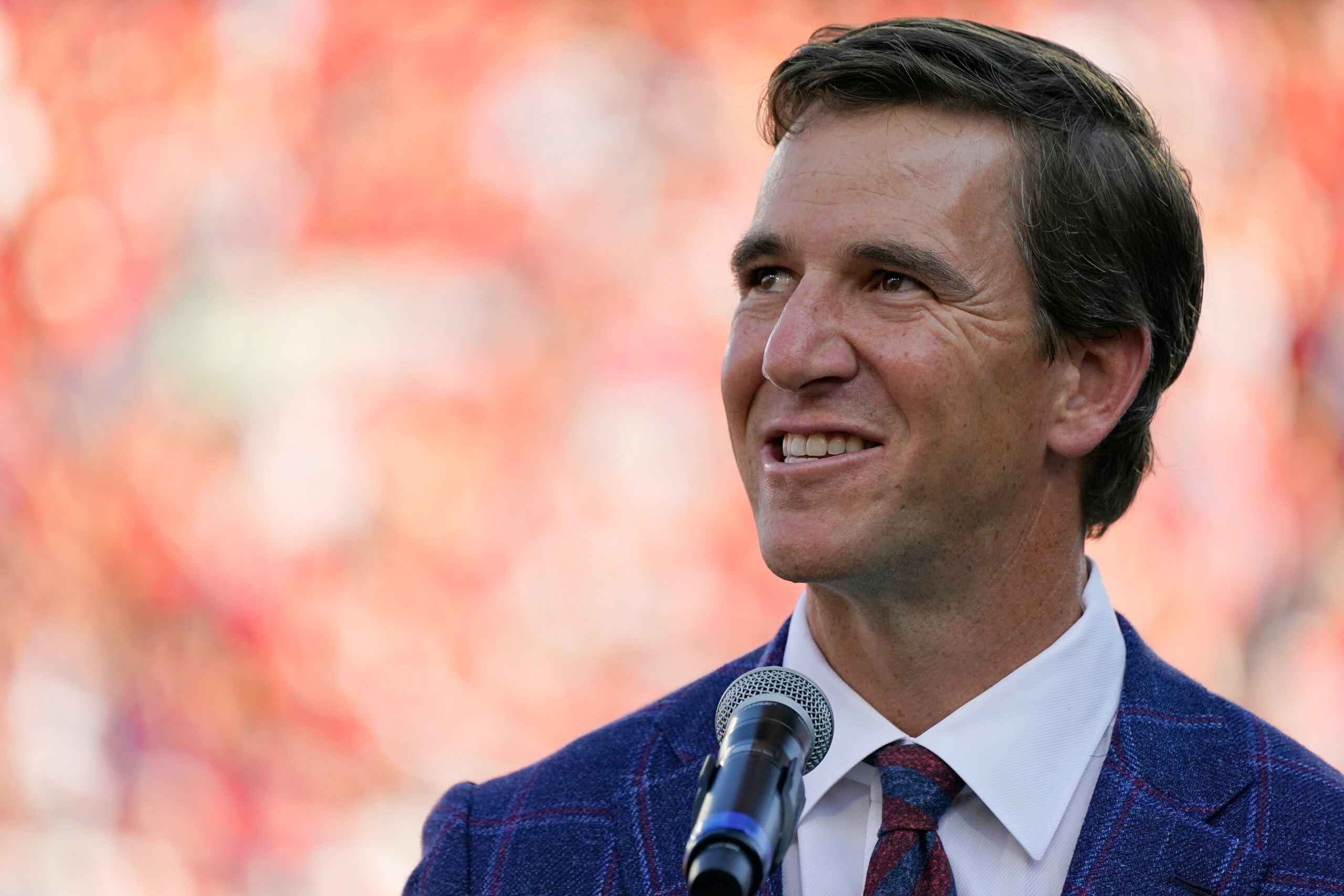 Former Mississippi quarterback Eli Manning addresses the crowd as his No. 10 jersey number is retired as part of the halftime jersey retirement ceremony at an NCAA college football game against LSU in Oxford, Miss., Saturday, Oct. 23, 2021. (AP Photo/Rogelio V. Solis)