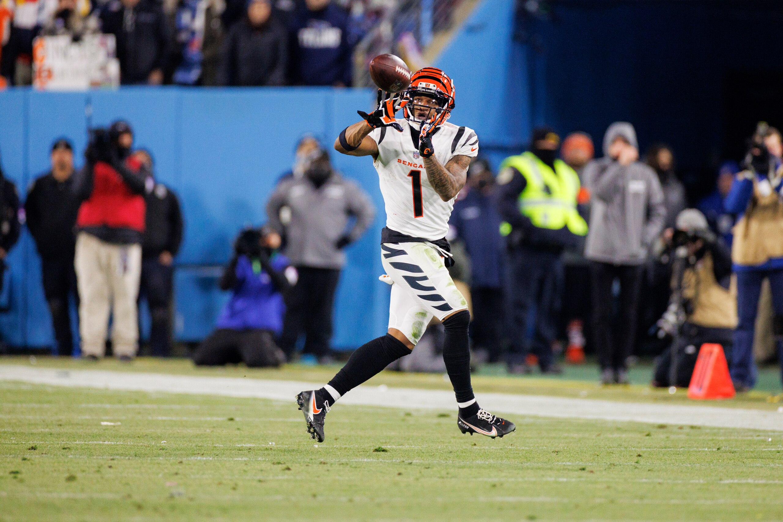 Cincinnati Bengals wide receiver Ja'Marr Chase (1) makes a pass reception before running out of bounds with a few seconds remaining during the fourth quarter of an NFL divisional playoff football game against the Tennessee Titans, Saturday, Jan. 22, 2022, in Nashville, Tenn. (AP Photo/Brett Carlsen)