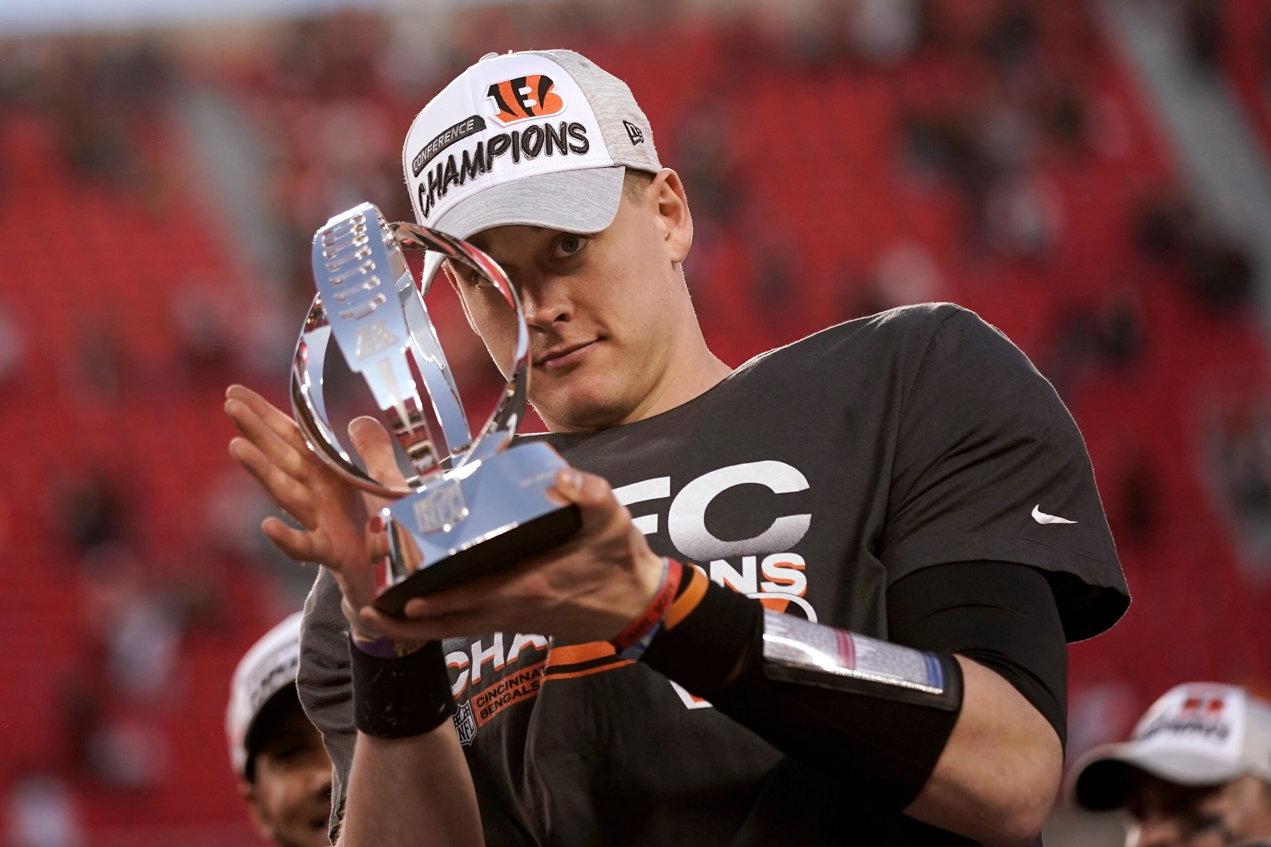 Cincinnati Bengals quarterback Joe Burrow (9) holds the Lamar Hunt trophy after an AFC championship NFL football game against the Kansas City Chiefs, Sunday, Jan. 30, 2022, in Kansas City, Mo. The Bengals won 27-24 in overtime. (AP Photo/Charlie Riedel)