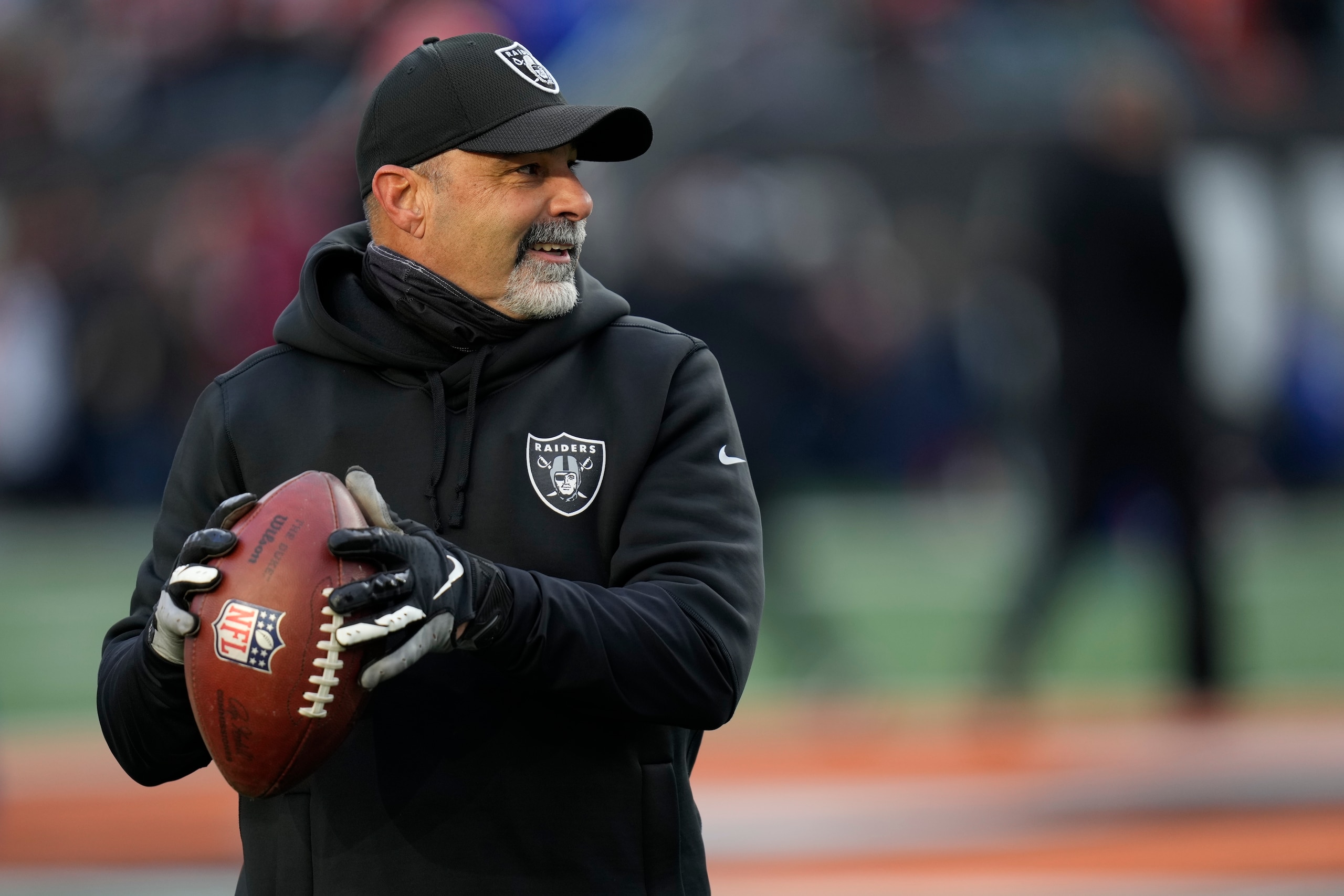 Las Vegas Raiders interim head coach Rich Bisaccia throws a pass before an NFL football game between the Cincinnati Bengals and the Las Vegas Raiders, Saturday, Jan. 15, 2022, in Cincinnati. (AP Photo/AJ Mast) Las Vegas Raiders interim head coach Rich Bisaccia throws a pass before an NFL football game between the Cincinnati Bengals and the Las Vegas Raiders, Saturday, Jan. 15, 2022, in Cincinnati. (AP Photo/AJ Mast)