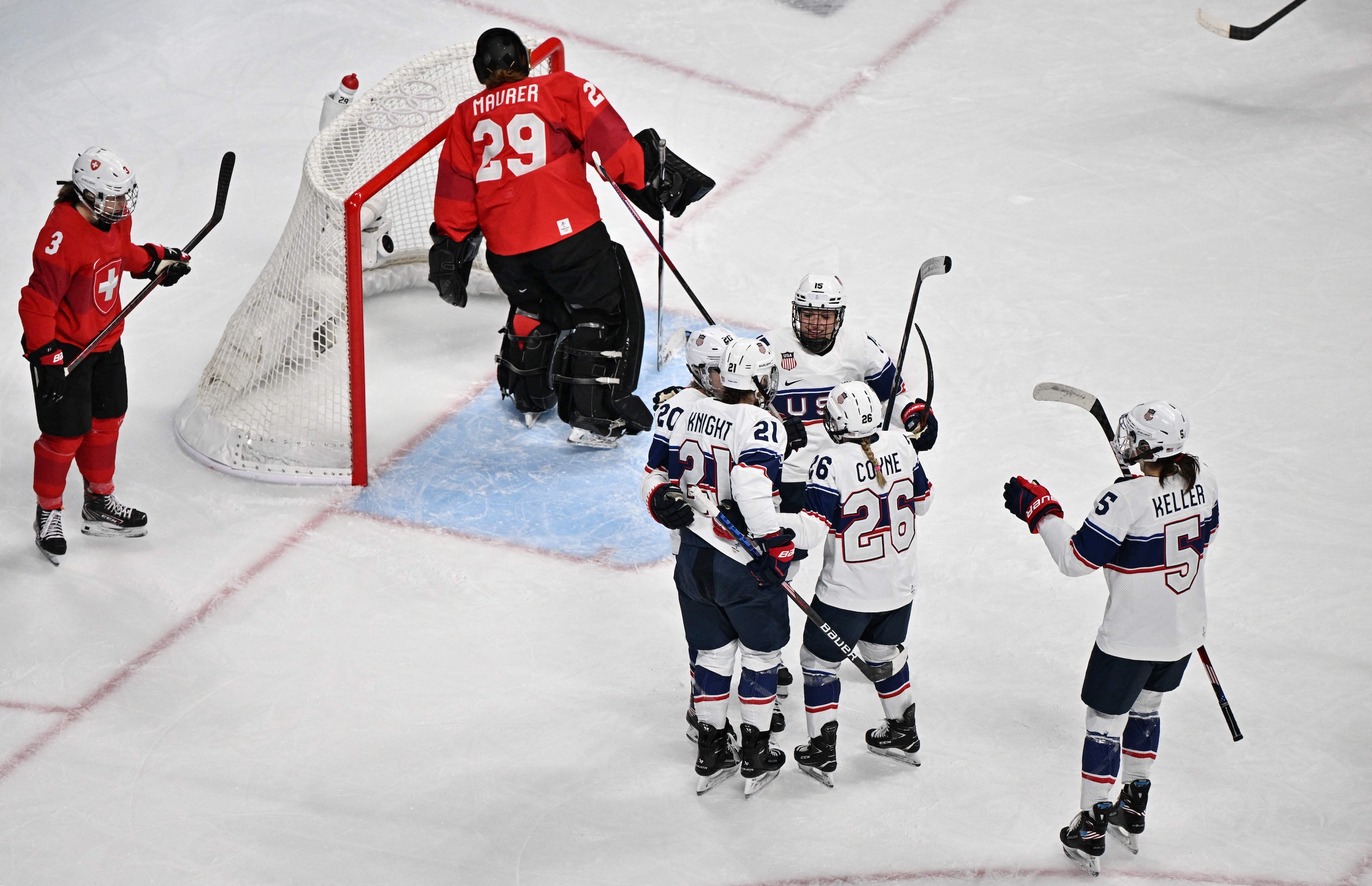 USA's Hilary Knight (L) celebrates with teammates after scoring a goal against Switzerland during the women's preliminary round group A match of the Beijing 2022 Winter Olympic Games ice hockey competition, at the Wukesong Sports Centre in Beijing on February 6, 2022. (Photo by ANTHONY WALLACE / AFP) (Photo by ANTHONY WALLACE/AFP via Getty Images)