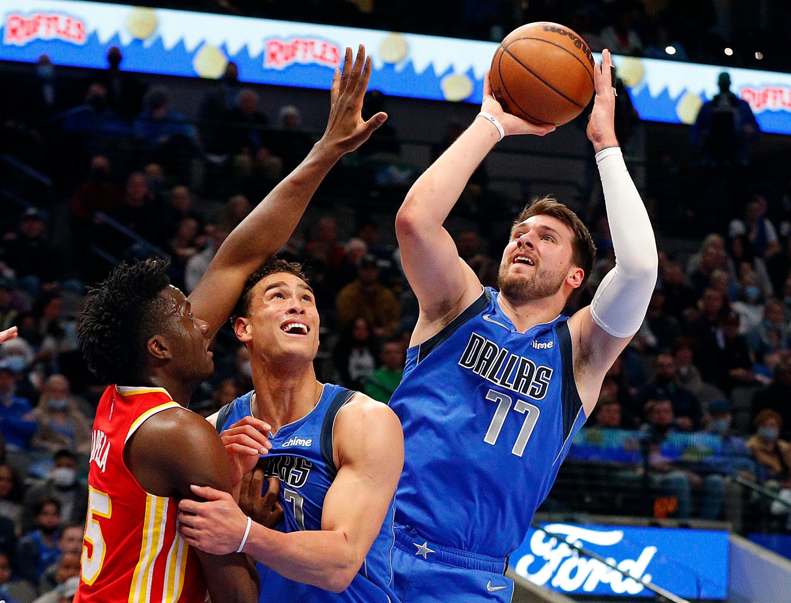 DALLAS, TEXAS - FEBRUARY 06: Luka Doncic #77 of the Dallas Mavericks puts up a shot as teammate Dwight Powell #7 screens Clint Capela #15 of the Atlanta Hawks in the first half at American Airlines Center on February 06, 2022 in Dallas, Texas. NOTE TO USER: User expressly acknowledges and agrees that, by downloading and or using this photograph, User is consenting to the terms and conditions of the Getty Images License Agreement. (Photo by Richard Rodriguez/Getty Images)