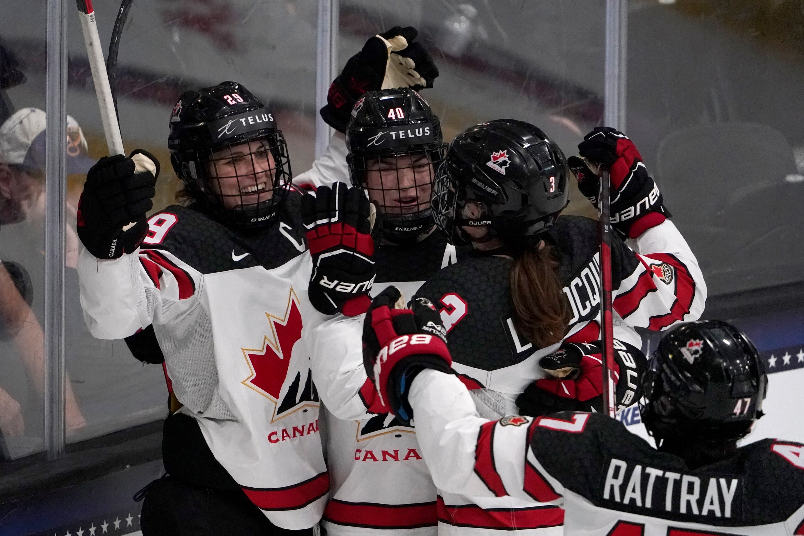 Canada's Marie-Philip Poulin, left, is congratulated by teammates after scoring the game-winning goal in overtime of a women's exhibition hockey game against the United States ahead of the Beijing Olympics Wednesday, Dec. 15, 2021, in Maryland Heights, Mo. (AP Photo/Jeff Roberson)