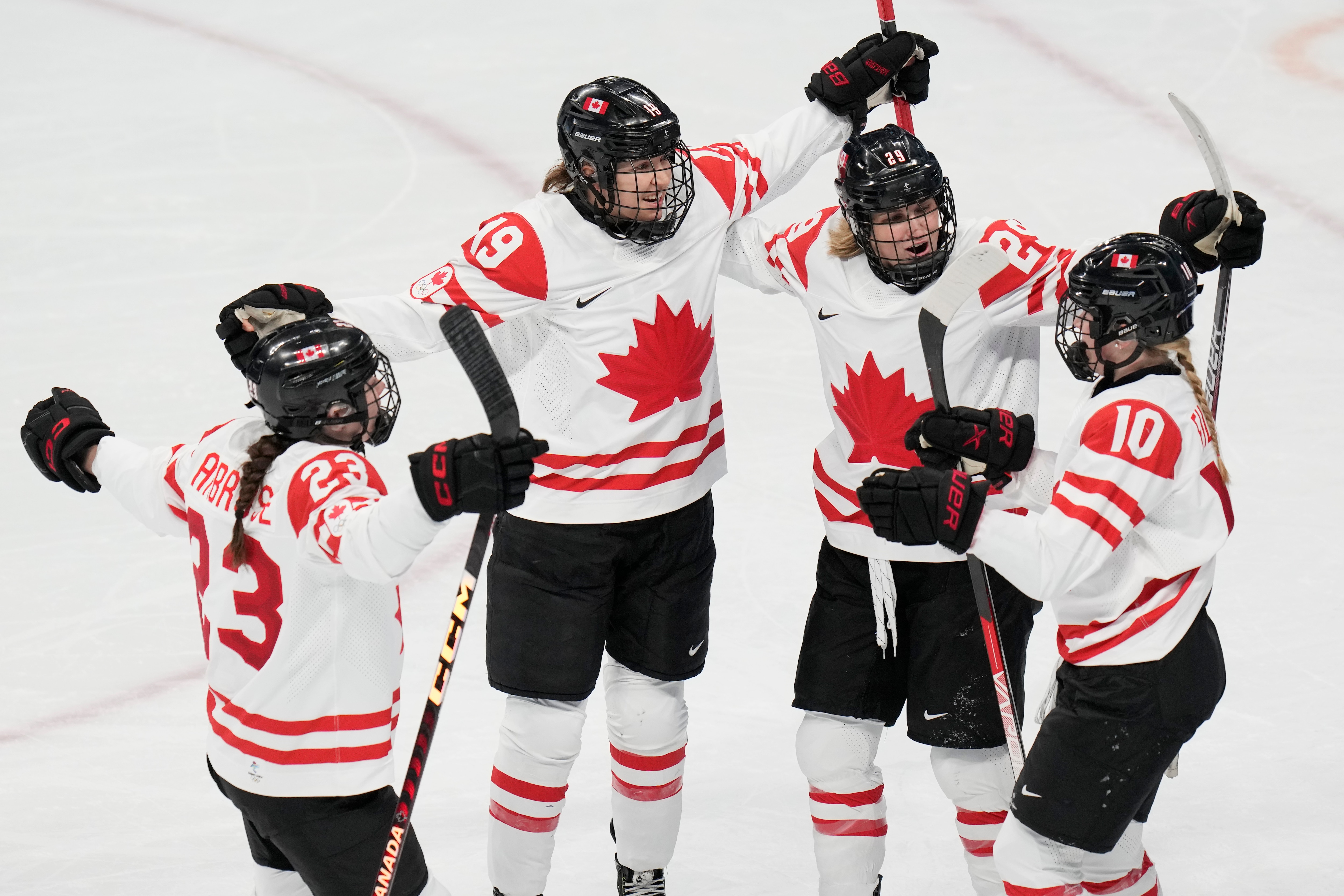 Canada's Brianne Jenner (19) celebrates with Erin Ambrose (23), Marie-Philip Poulin (29) and Sarah Fillier (10) after Jenner scored a goal against the United States during a preliminary round women's hockey game at the 2022 Winter Olympics, Tuesday, Feb. 8, 2022, in Beijing. (AP Photo/Petr David Josek)