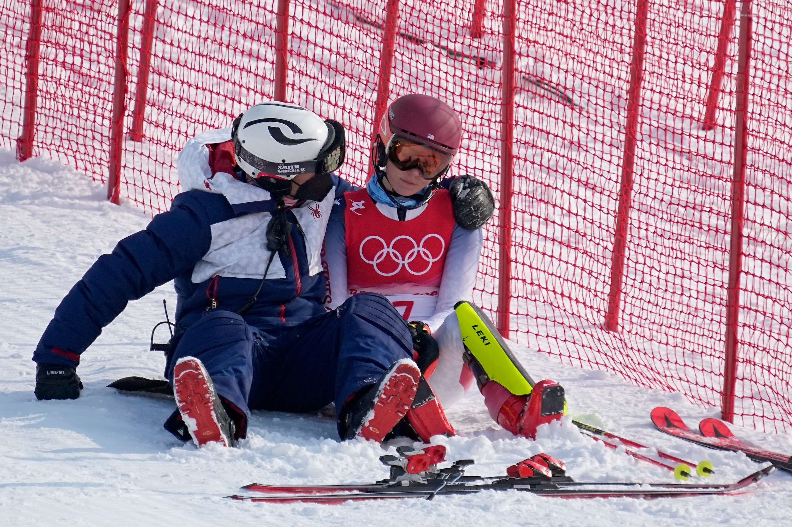 A team member consoles Mikaela Shiffrin, of the United States after she skied out in the first run of the women's slalom at the 2022 Winter Olympics, Wednesday, Feb. 9, 2022, in the Yanqing district of Beijing. (AP Photo/Robert F. Bukaty)