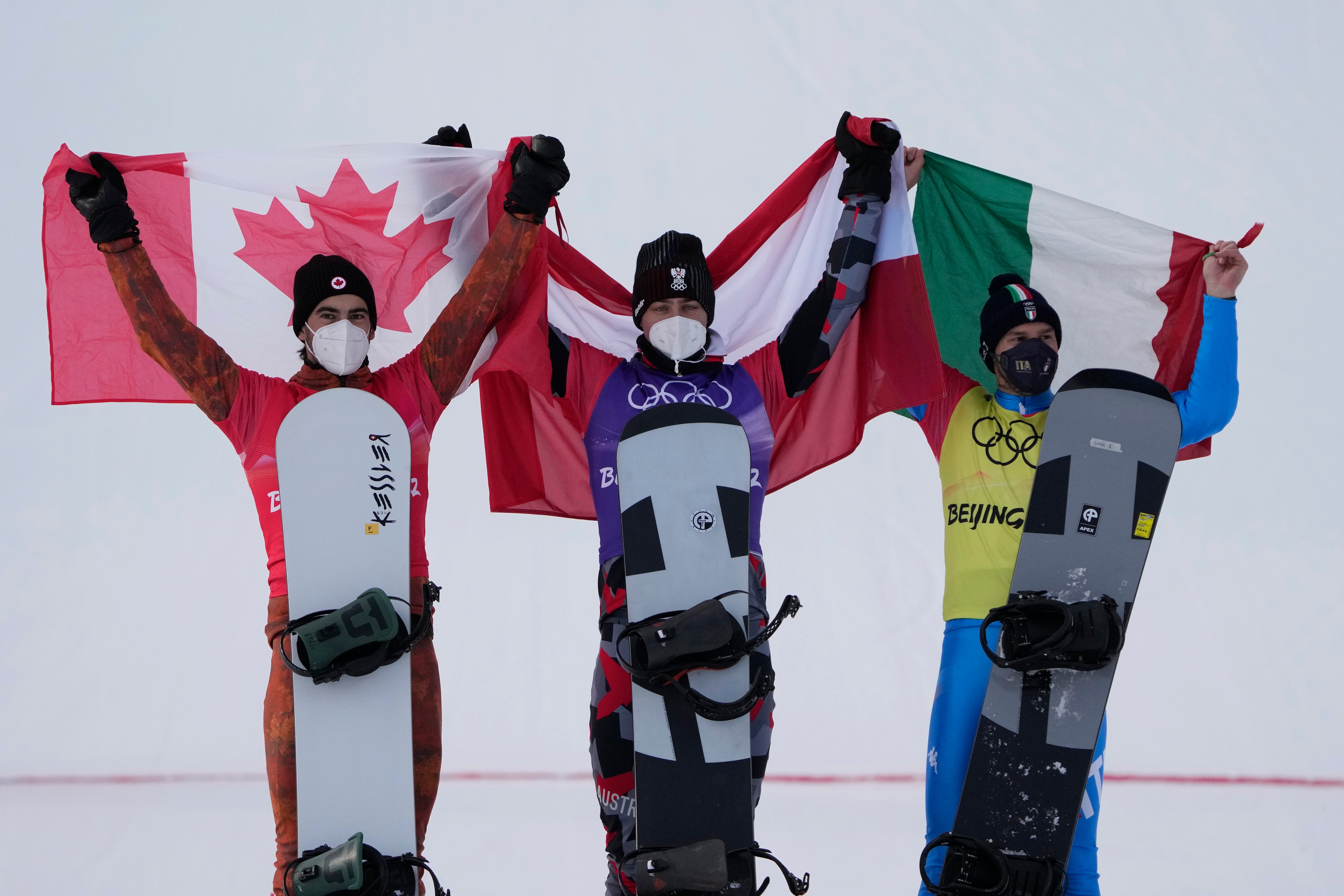 From left silver medal winner Canada's Éliot Grondin, gold medal winner Austria's Alessandro Haemmerle and bronze medal winner Italy's Omar Visintin celebrate during the venue award ceremony for during the men's cross finals at the 2022 Winter Olympics, Thursday, Feb. 10, 2022, in Zhangjiakou, China. (AP Photo/Lee Jin-man)