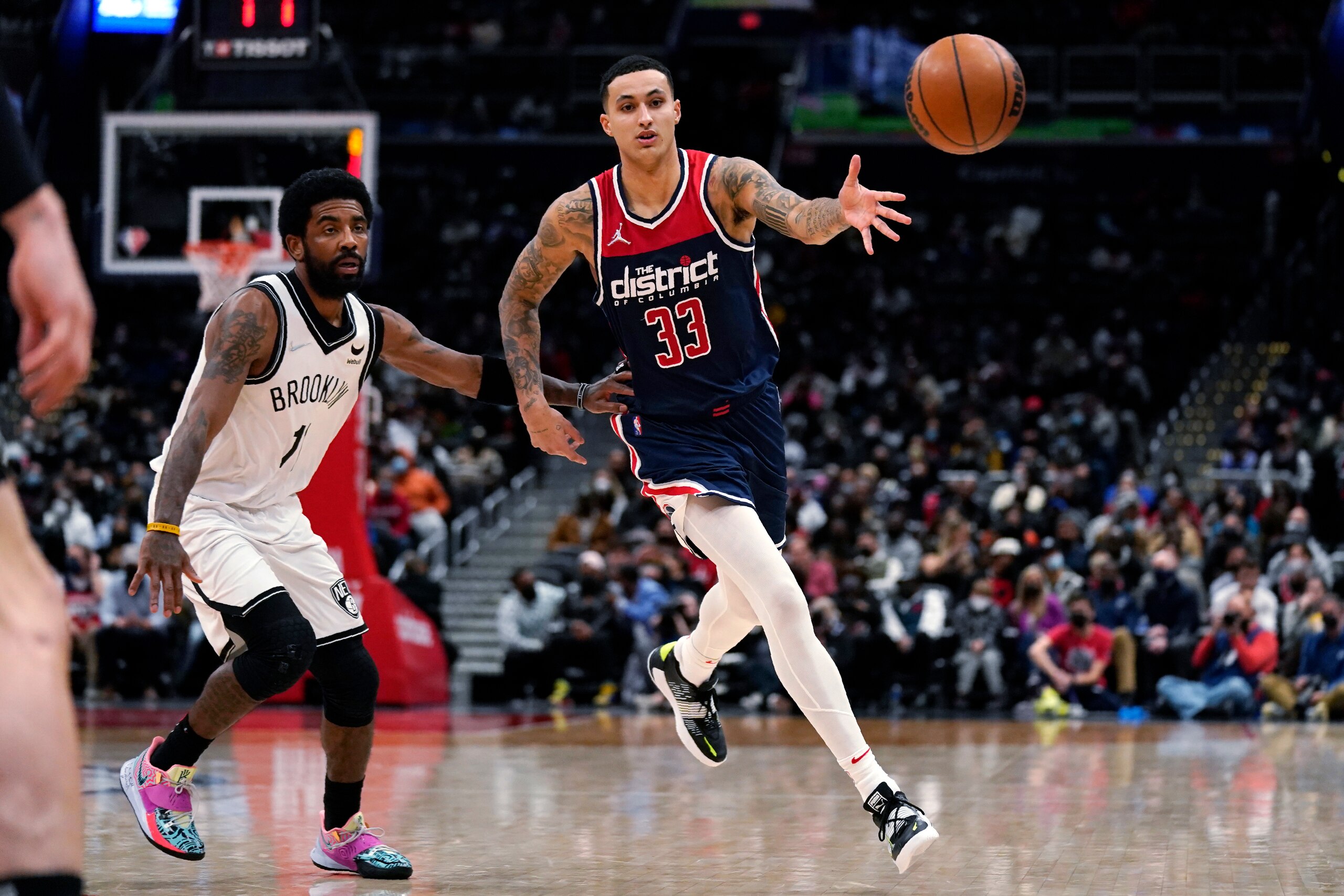 Brooklyn Nets guard Kyrie Irving (11) defends against Washington Wizards forward Kyle Kuzma (33) during the first half of an NBA basketball game Thursday, Feb. 10, 2022, in Washington. (AP Photo/Evan Vucci)