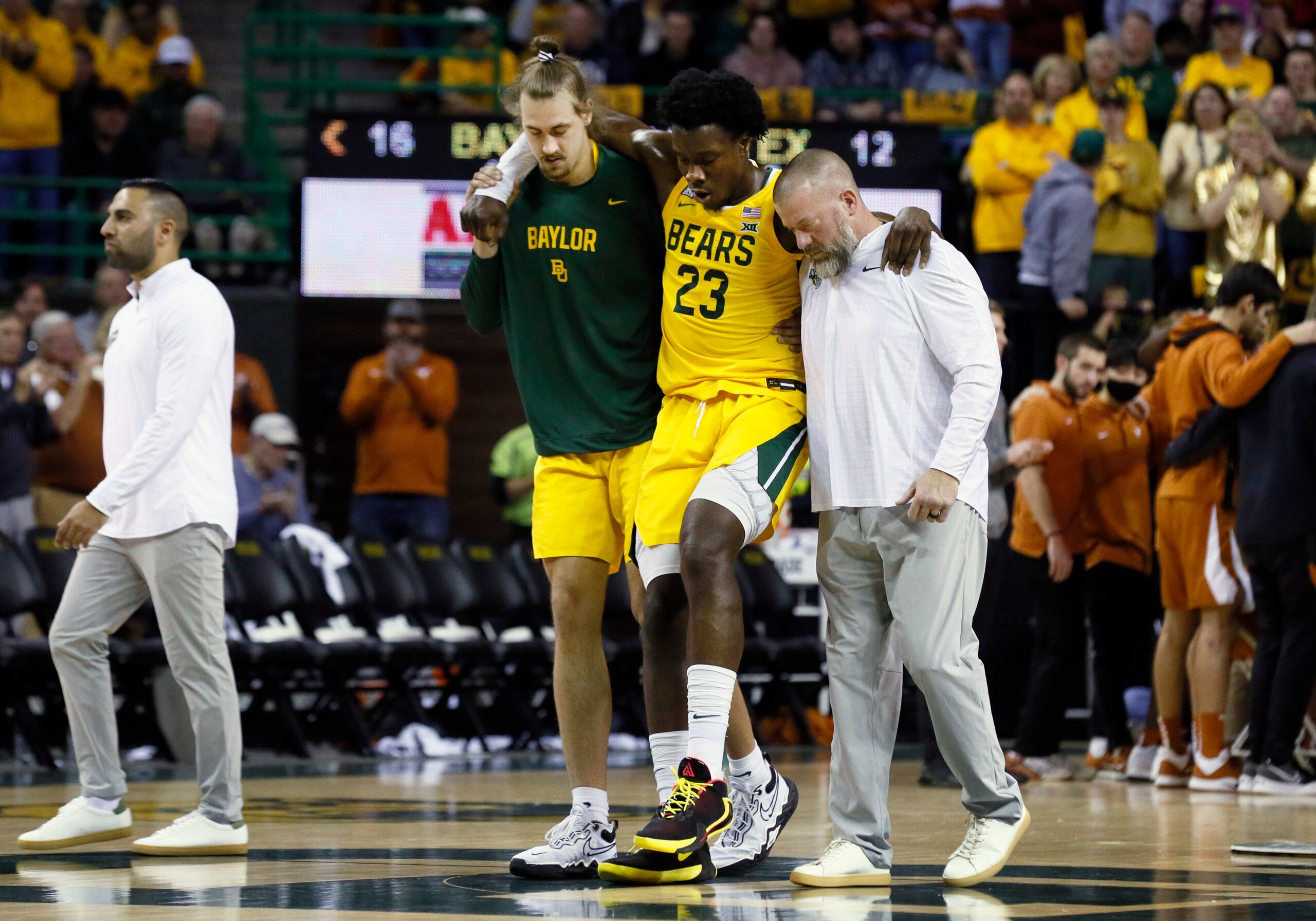 Baylor forward Jonathan Tchamwa Tchatchoua (23) is helped from the court as he leaves the game with an apparent leg injury during the first half of an NCAA college basketball game against Texas on Saturday, Feb. 12, 2022, in Waco, Texas. (AP Photo/Ray Carlin)